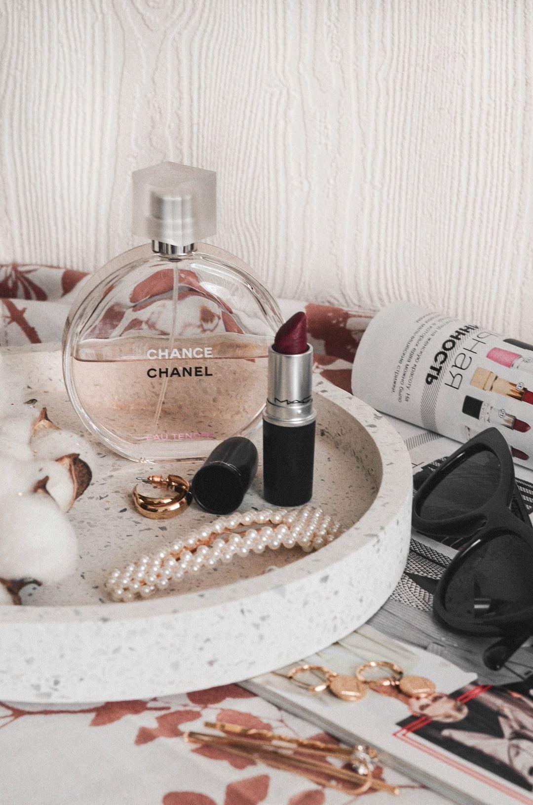 1080x1631 Chanel perfume bottle beside maroon lipstick photo