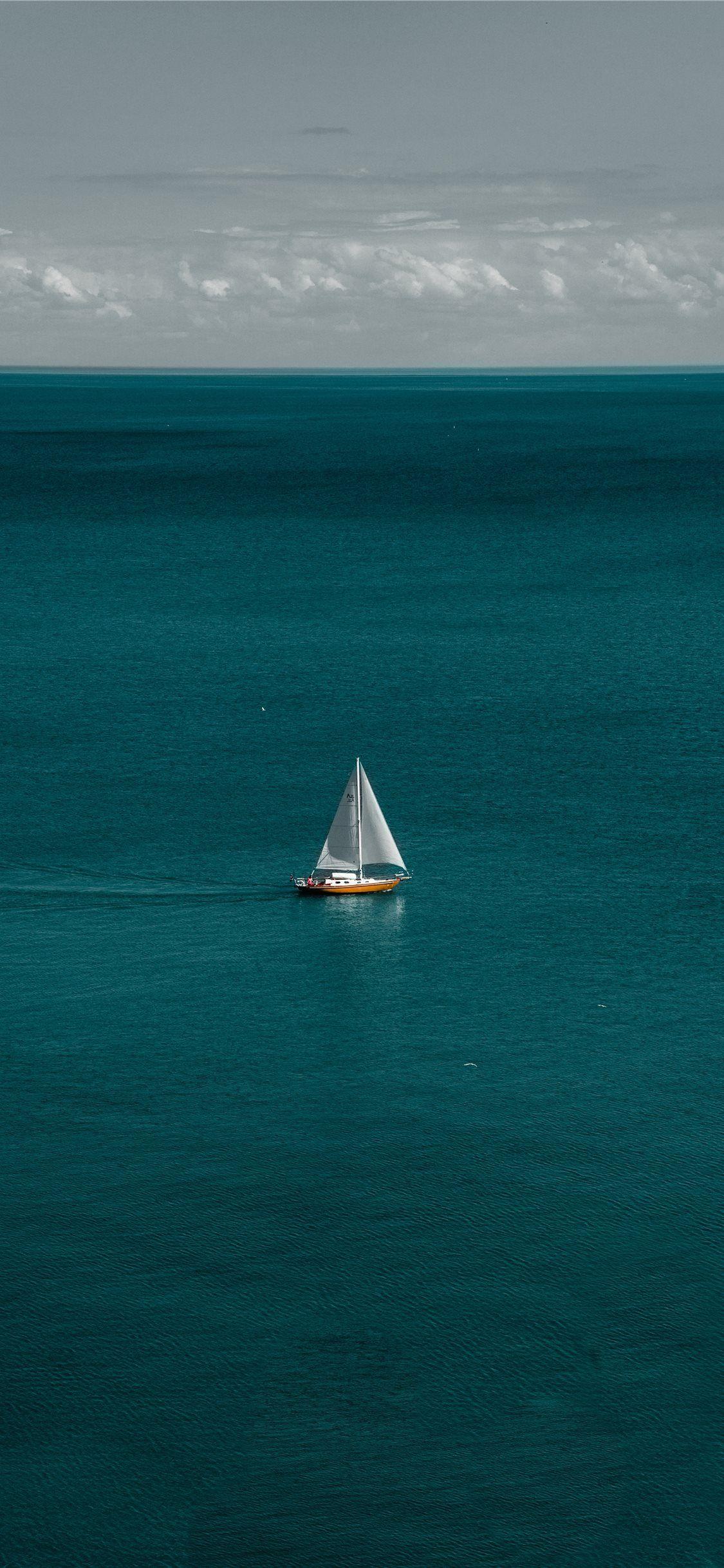 1125x2436 white and brown boat in body of water iPhone X Wallpaper Free Download