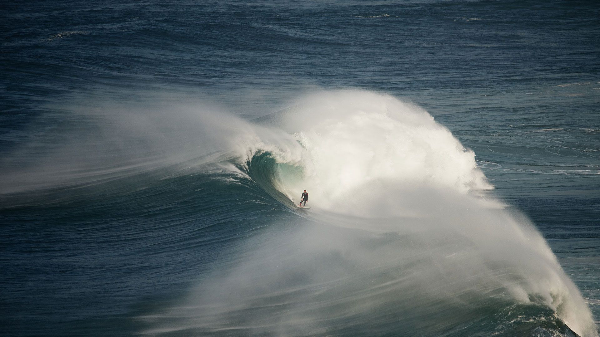 1920x1080 Surfer riding a wave in Nazaré, Portugal