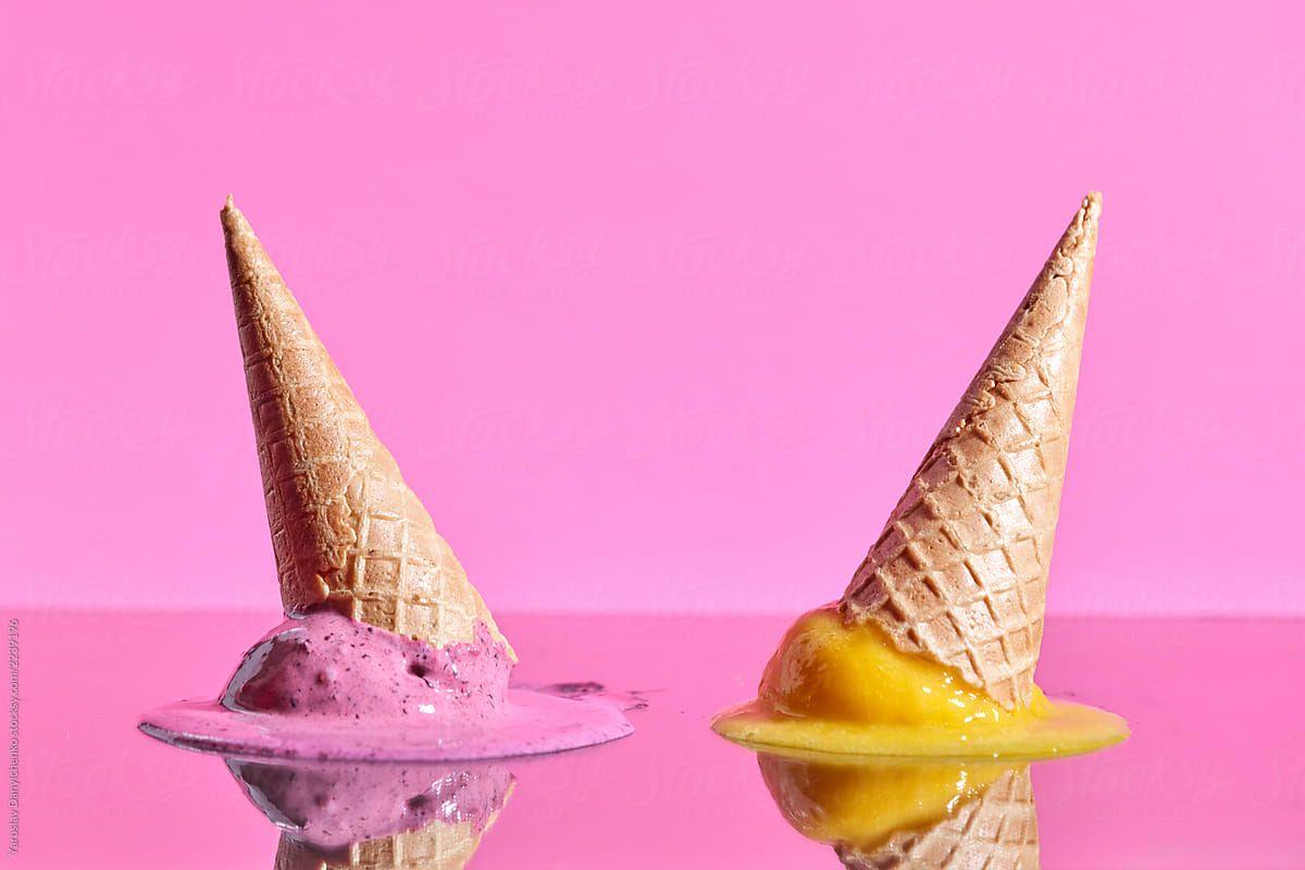 1200x800 Fruit melting ice cream with wafer cones reflected on a pink glossy background with copy space. Summer dessert