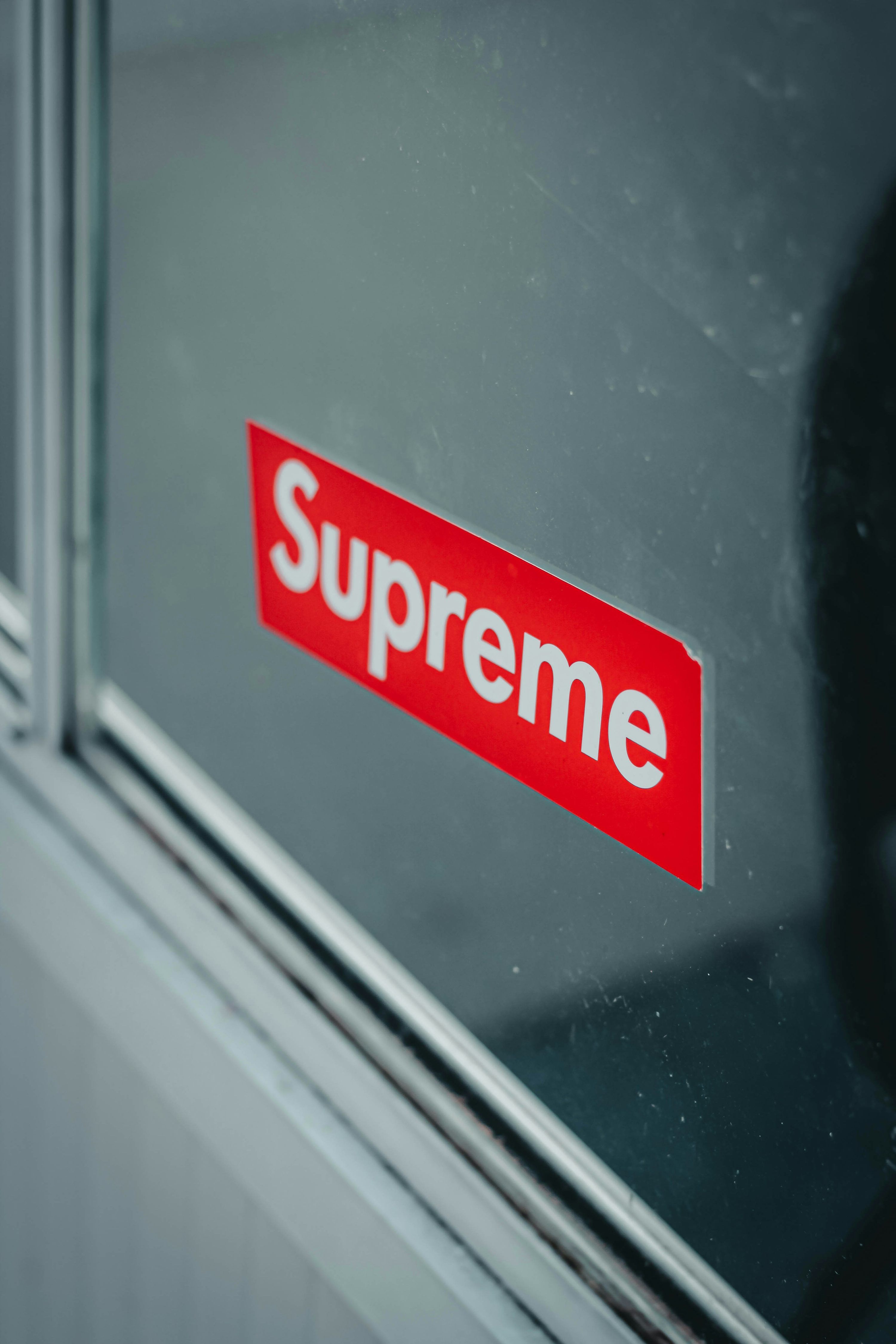 3000x4500 A red supreme sticker on a glass door photo