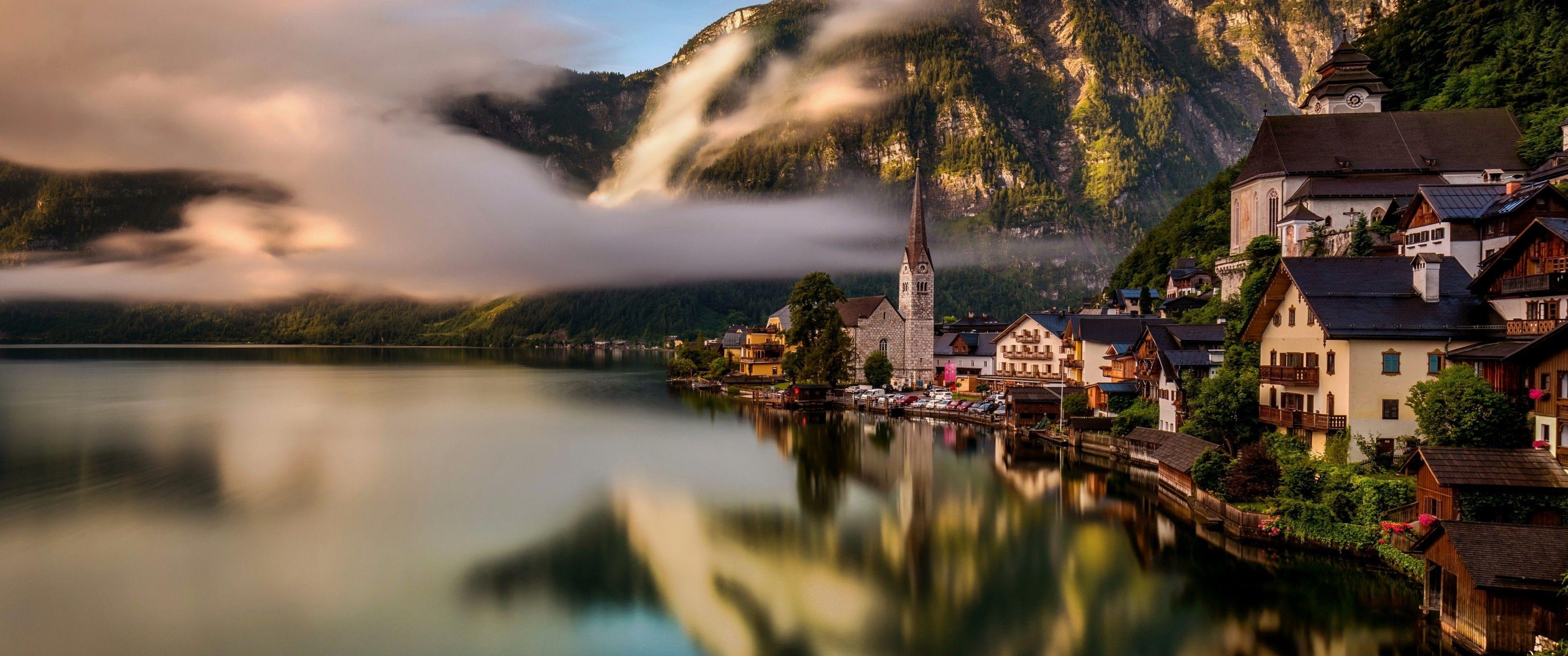 3440x1440 Download 3440x1440 Austria, Hallstatt, Village, Buildings, Lake, Clouds, Mountain, Reflection Wallpaper