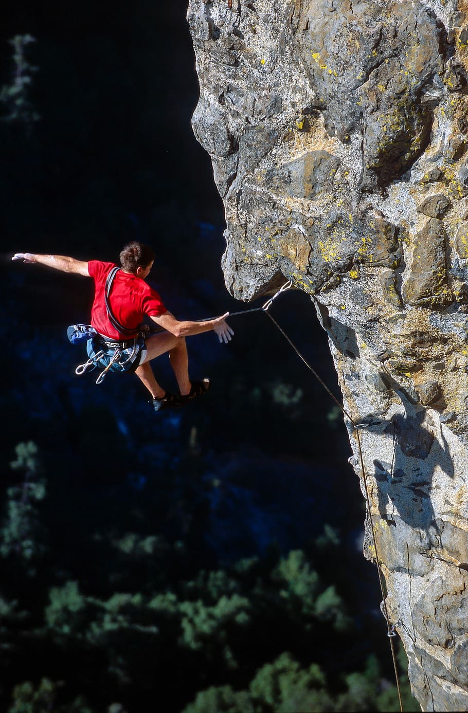 910x1387 HD wallpaper: person rock climbing, man jumping at cliff with rope at daytime