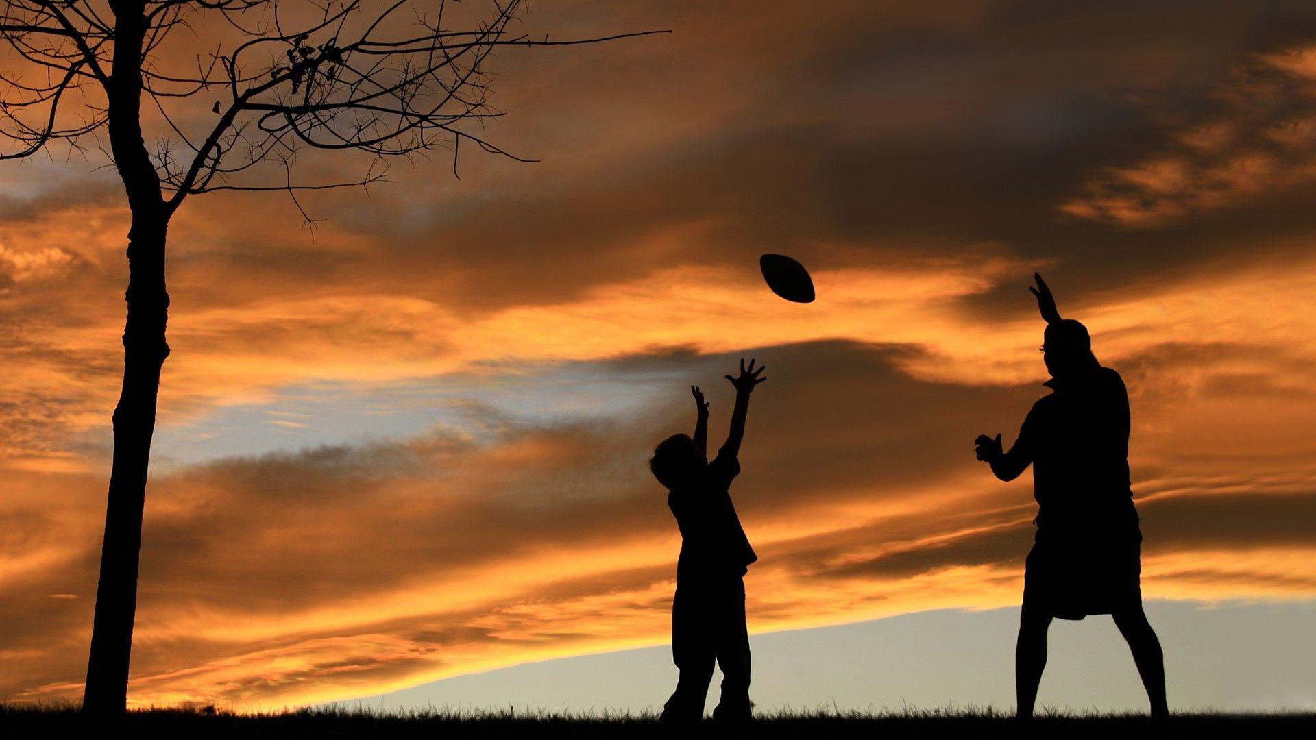 1920x1080 Silhouette of father playing football with his son. Windows 10 Spotlight Image