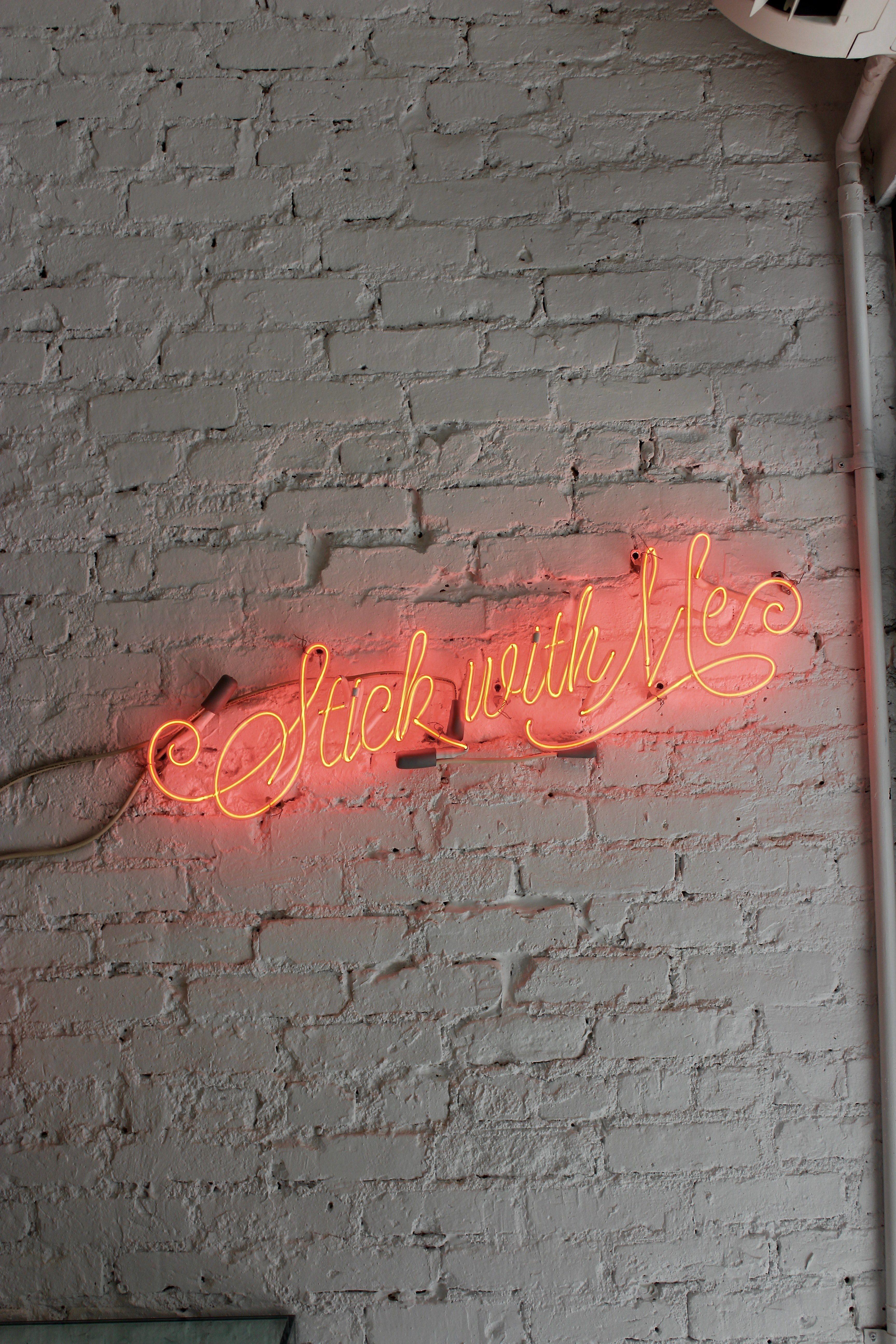 3456x5184 Wallpaper / a red neon with stick with me written in cursive on a white brick wall, stick with me neon 4k wallpaper