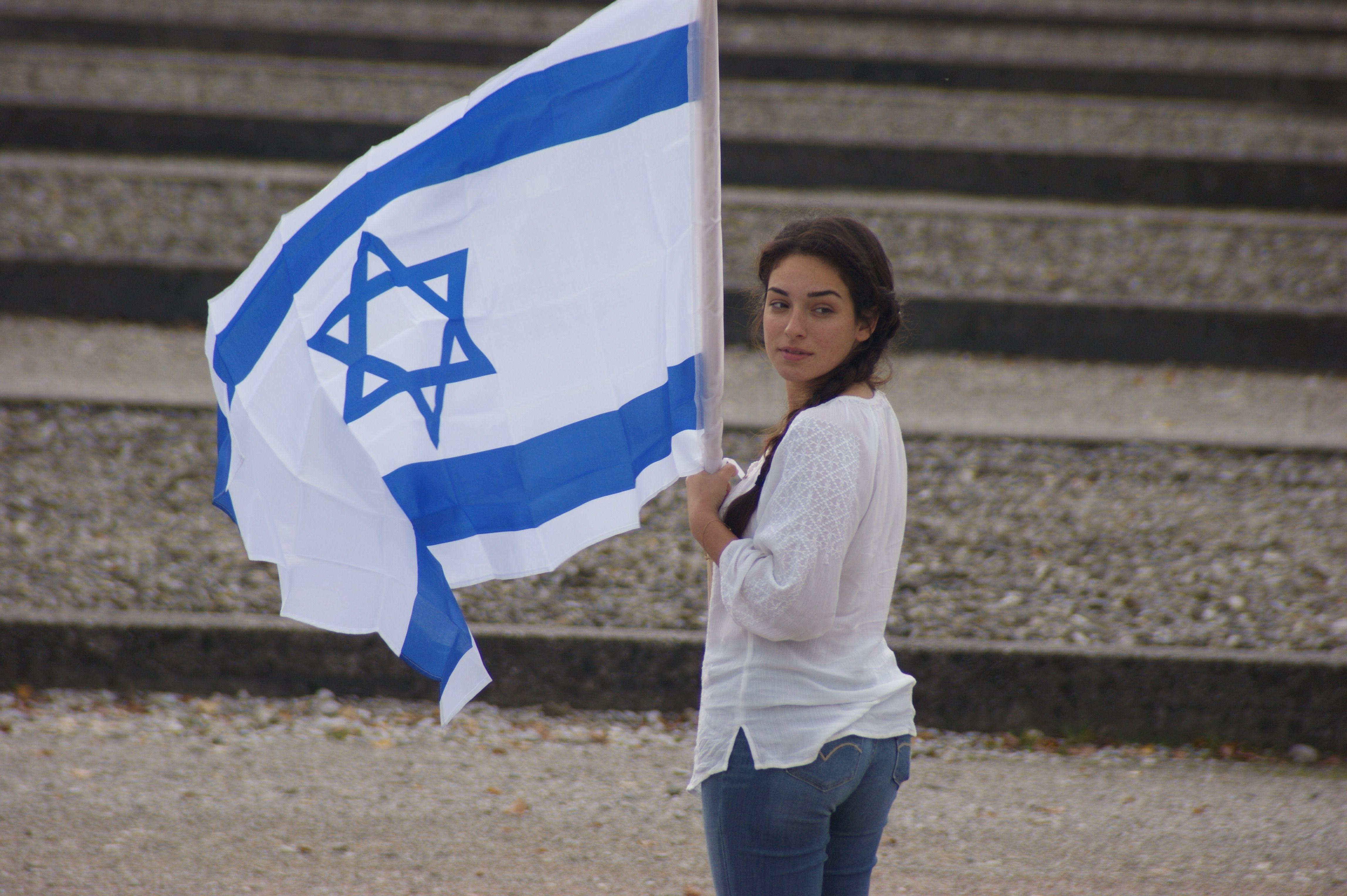 4592x3056 women's white long sleeve shirt and blue denim jeans and israel flag free image