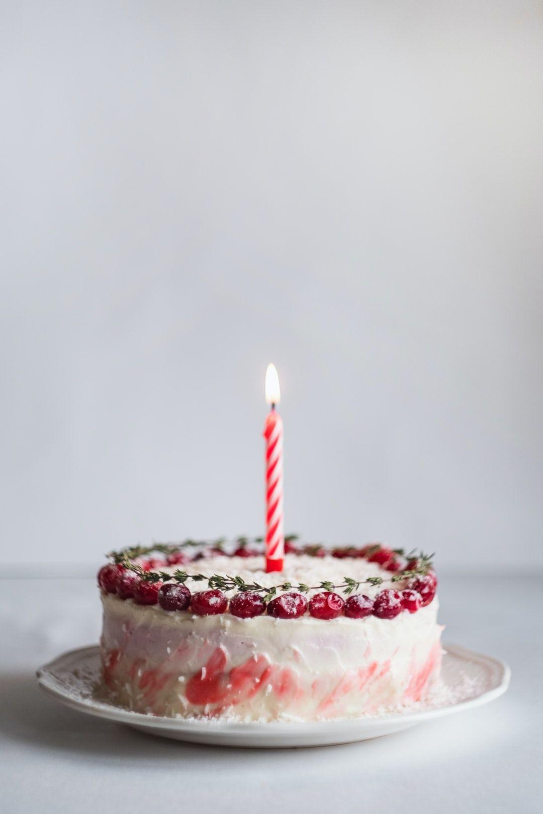 1080x1620 white and pink covered cake with lightened candle photo