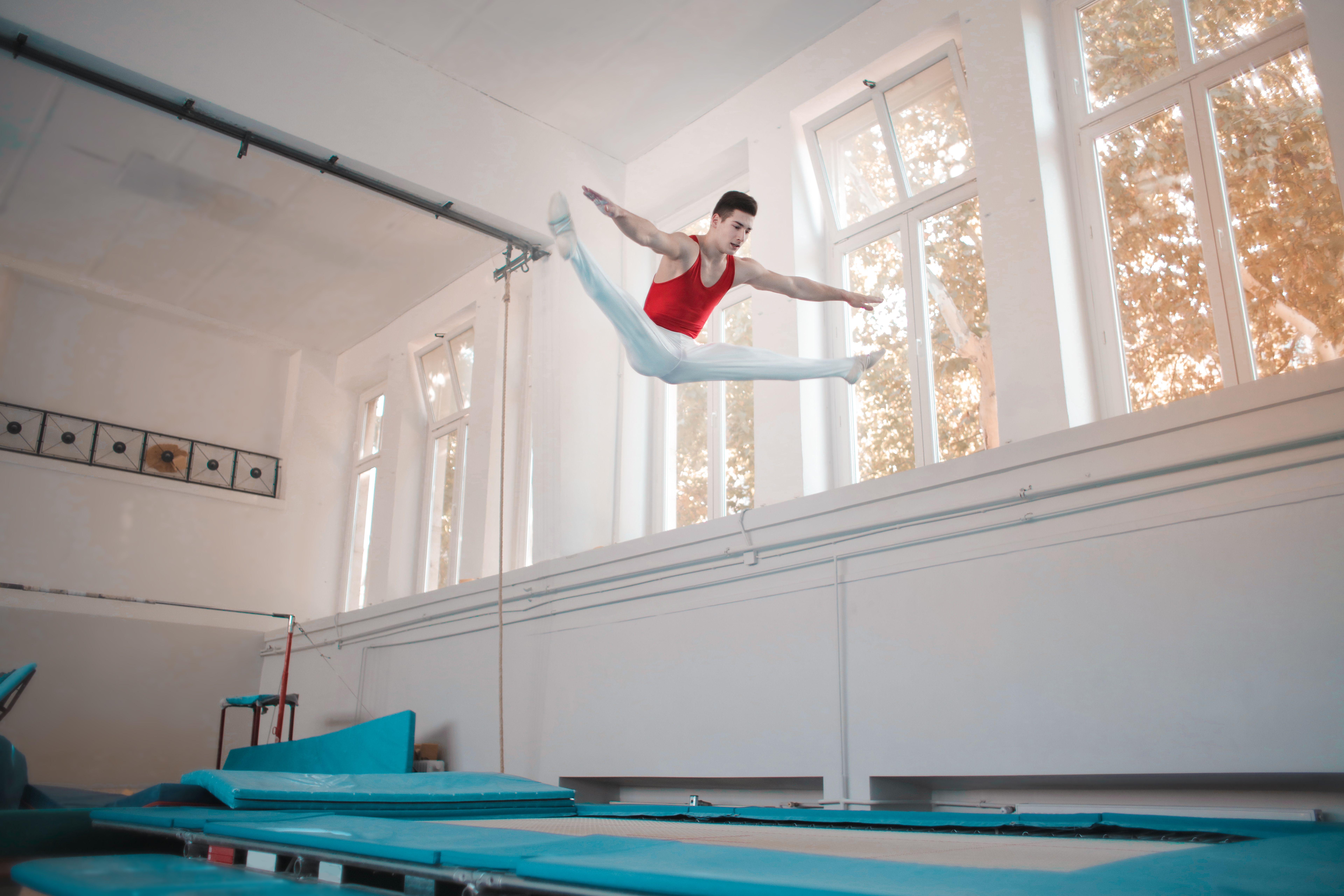 7680x5120 Young professional gymnast jumping on trampoline · Free