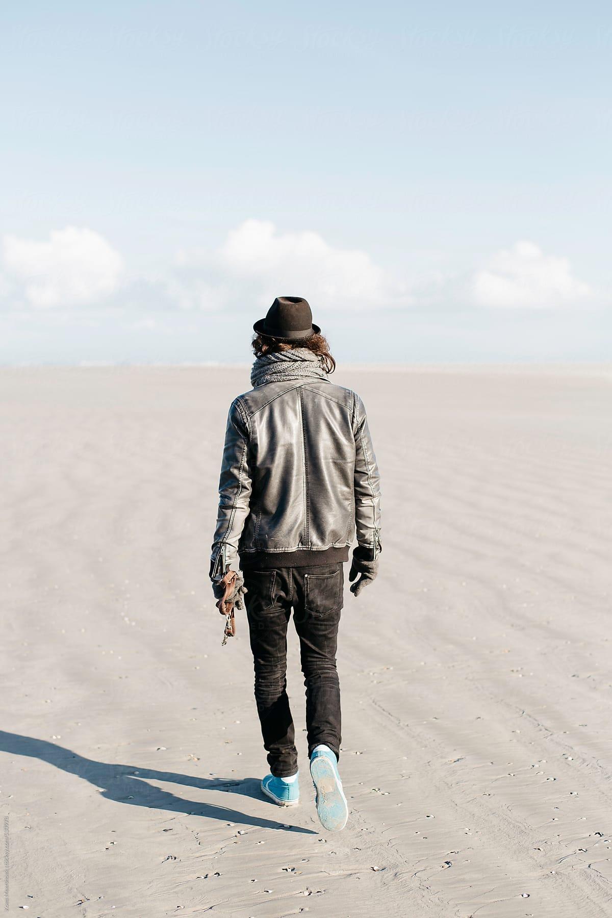1200x1800 Hip young man walking alone on the beach.