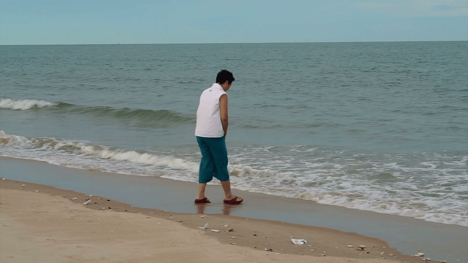 1920x1080 Asian senior woman walking alone along the beach enjoying nature Stock Video Footage