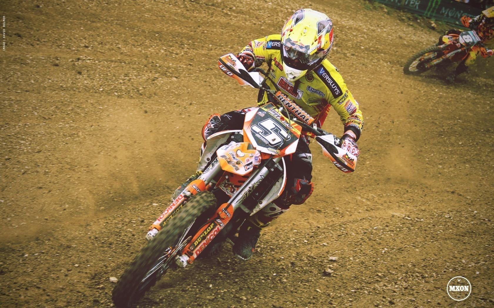 1680x1050 Man with yellow motocross helmet riding orange motocross dirt bike
