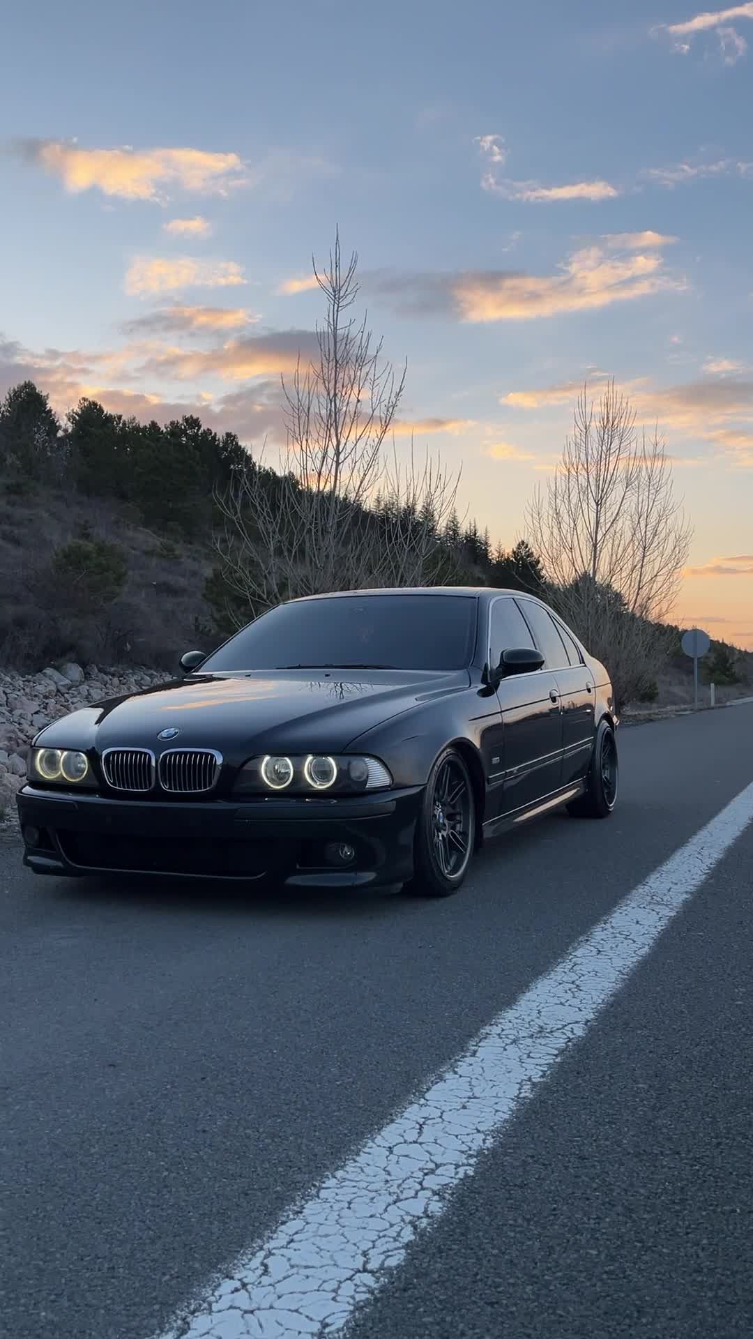 1080x1920 A black bmw car driving down the road