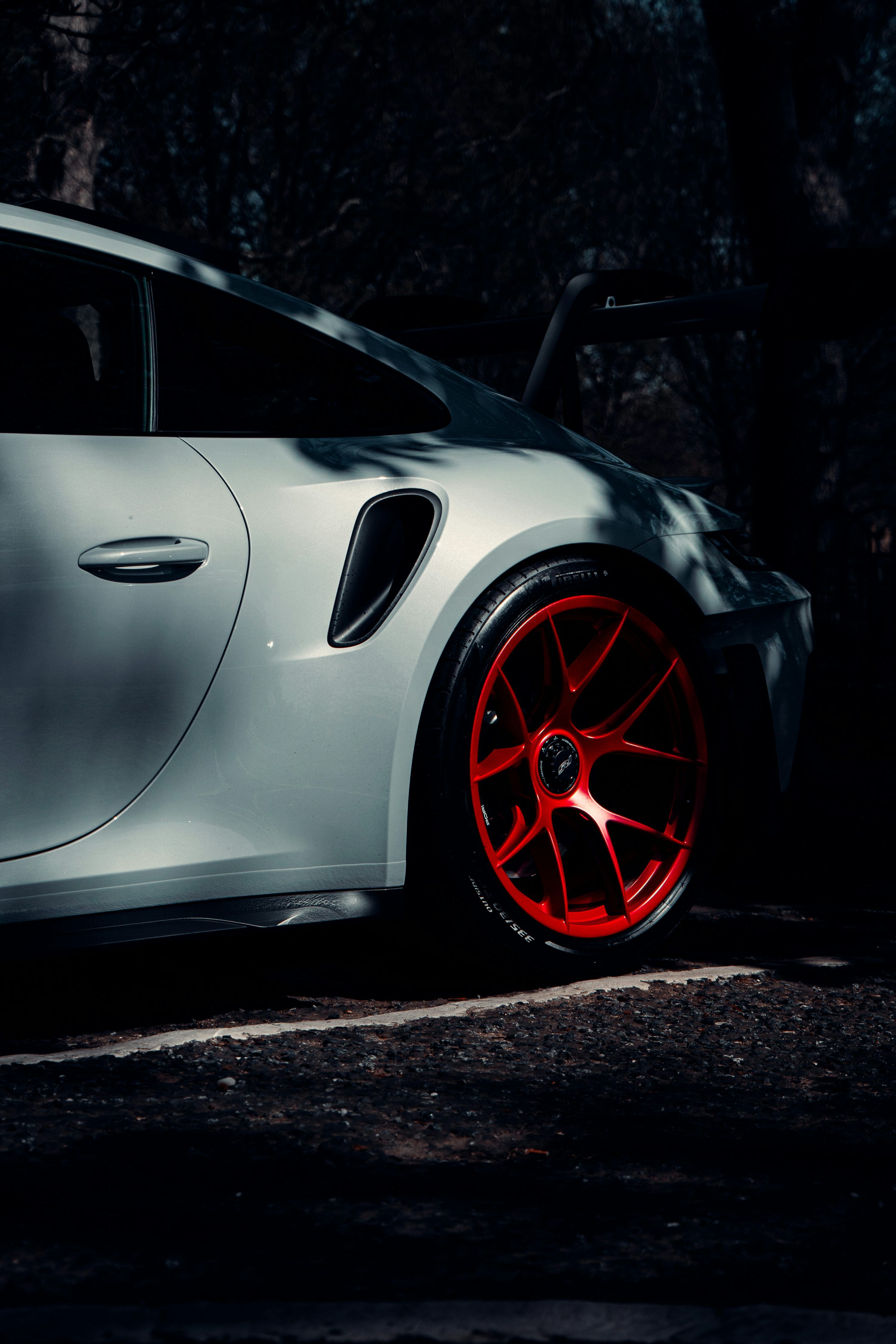 3000x4500 A sleek porsche with bright red rims