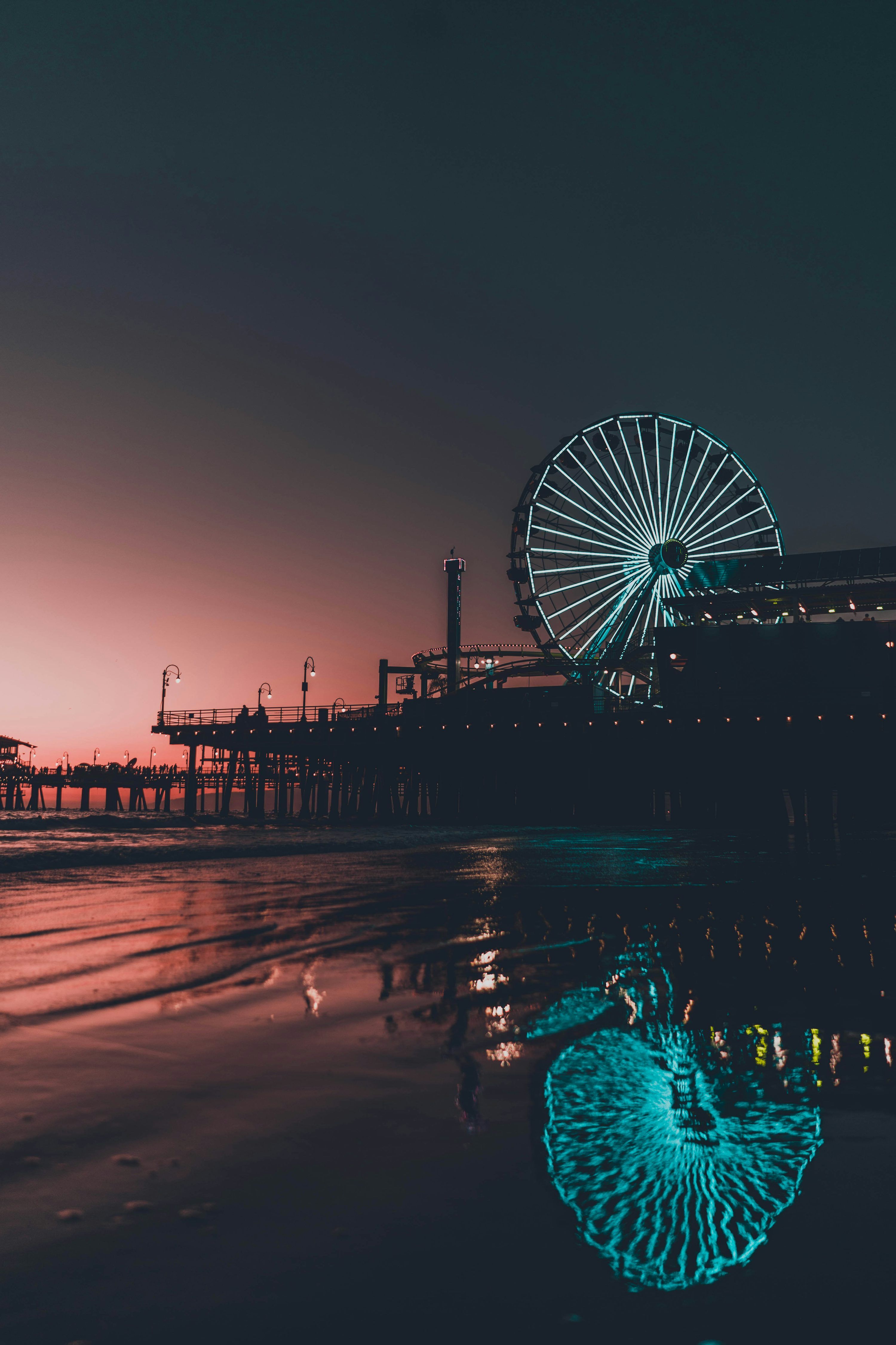 3000x4500 A ferris wheel by a body of water at night