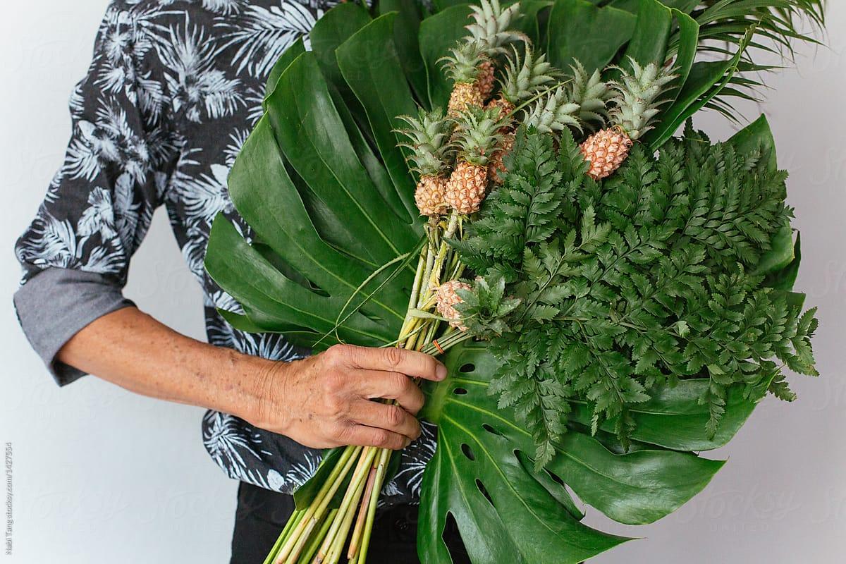1200x800 Senior hipster man holding tropical plant bouquet and mini pineapple by Nabi Tang, Pineapple