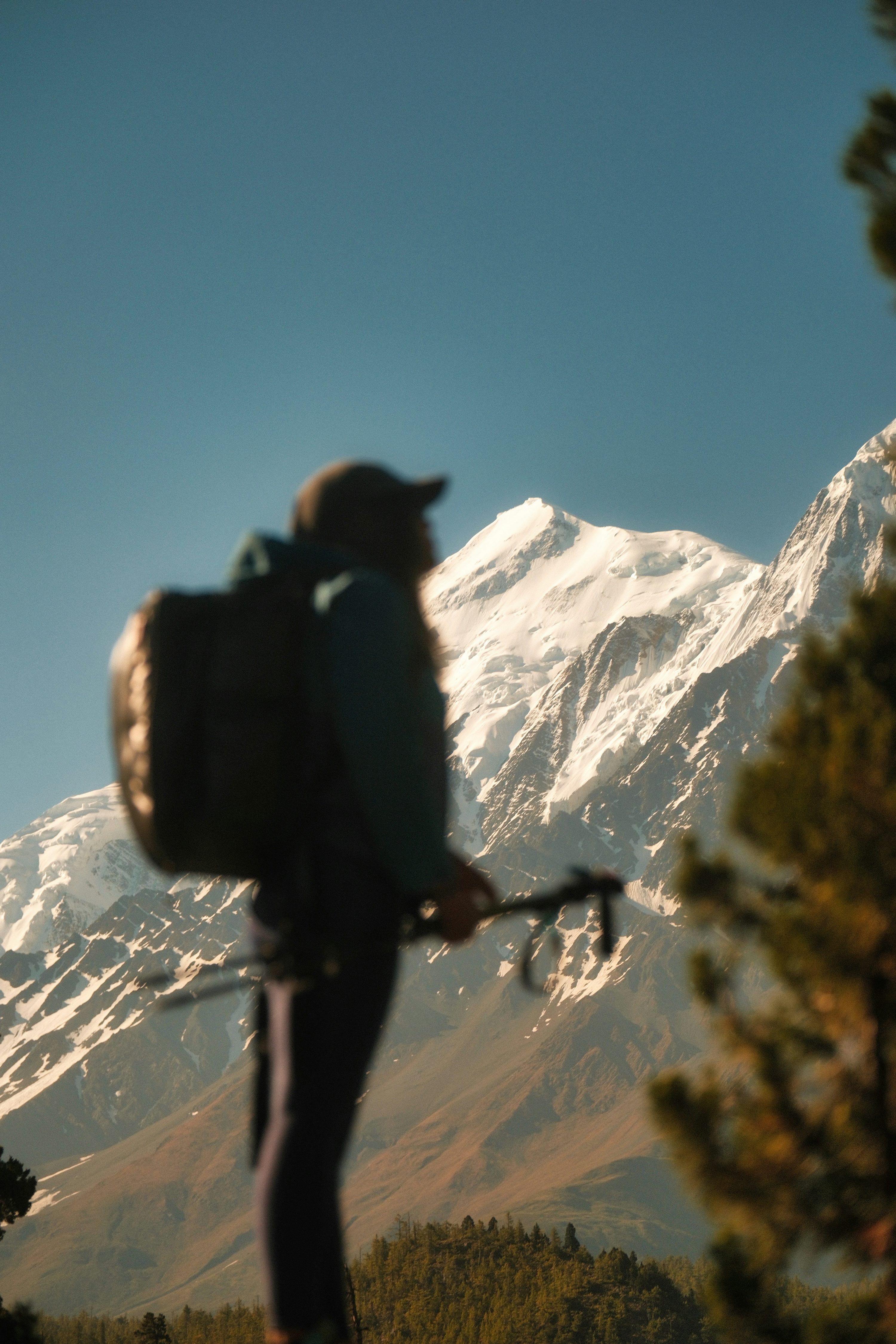 3000x4500 Pendaki dengan ransel mengagumi gunung tertutup salju yang megah. Gratis di