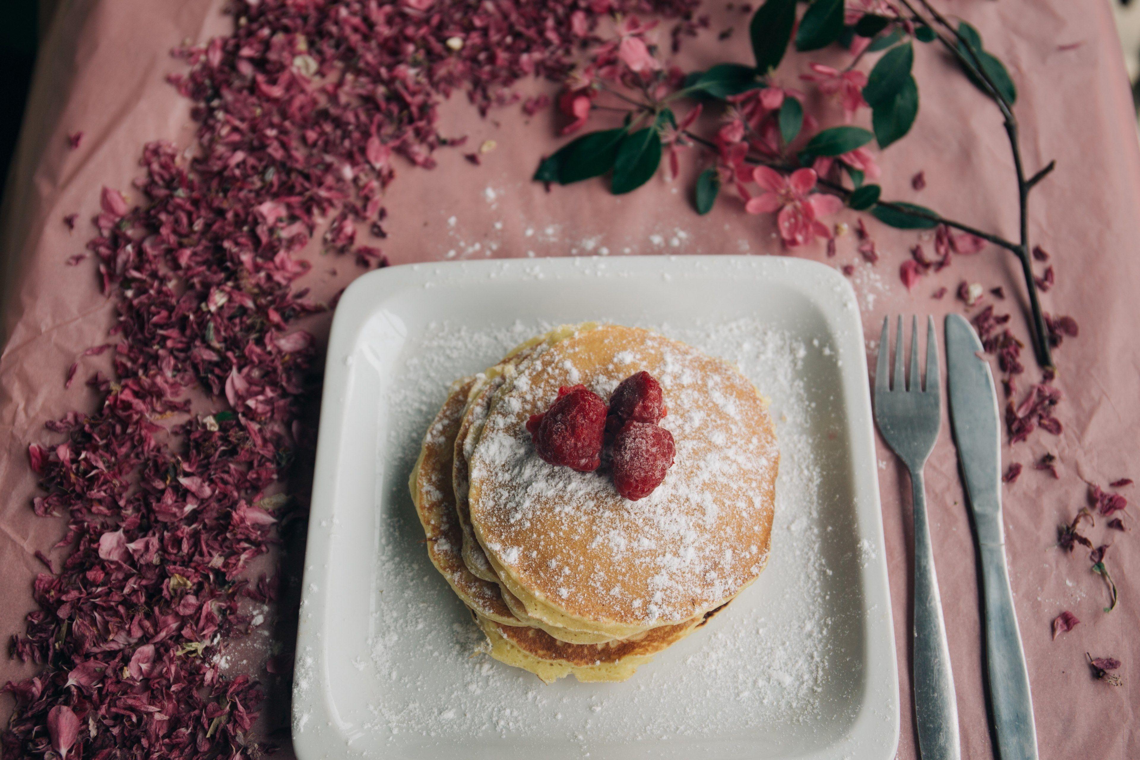 3840x2560 Wallpaper / delicious looking pancakes covered in berries and powdered sugar on a plate that is sitting on a table with flowers on it, millennial pink pancakes 4k wallpaper
