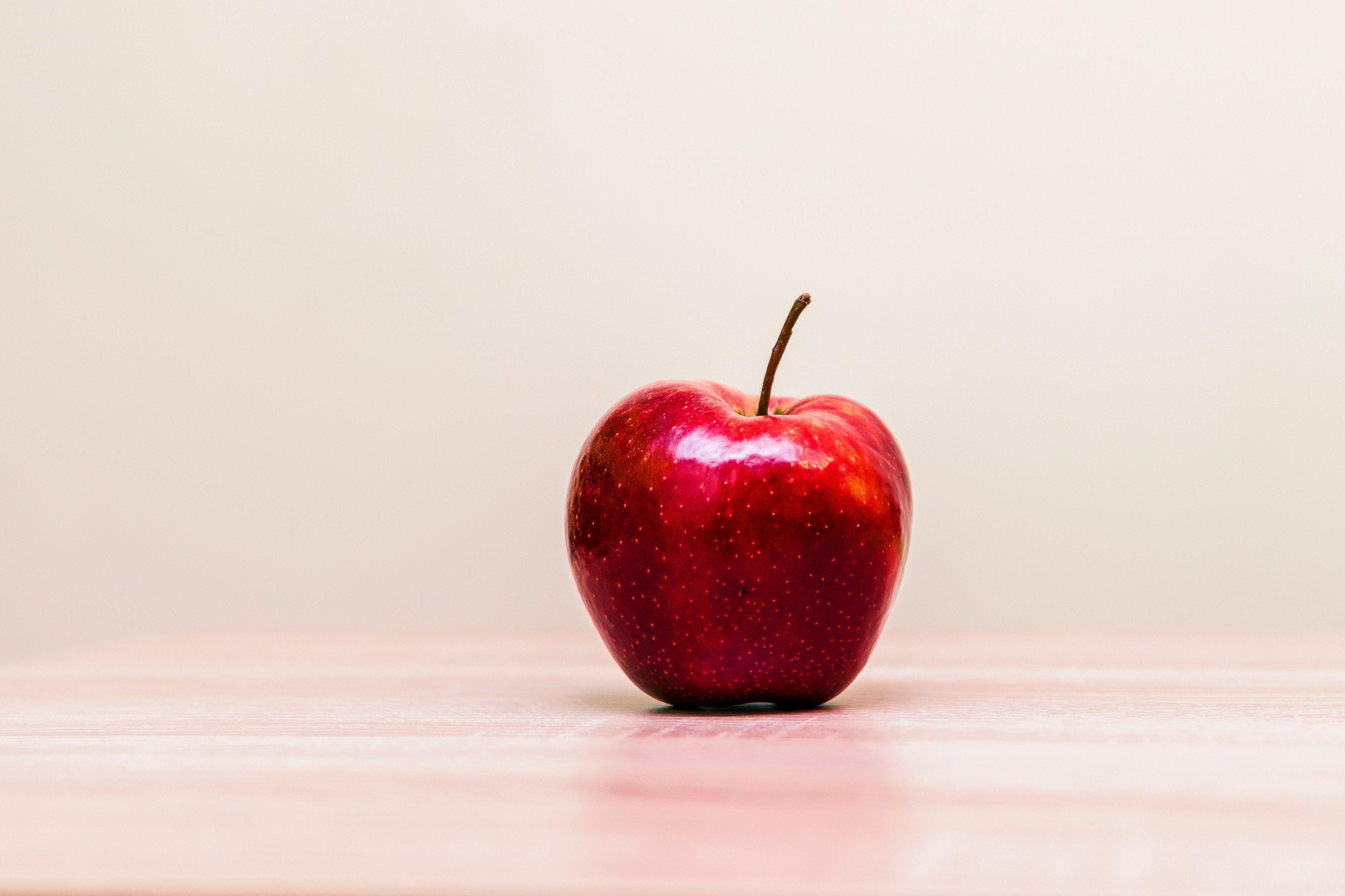 3840x2560 Wallpaper / a glossy red apple on a wooden surface, productred 4k wallpaper