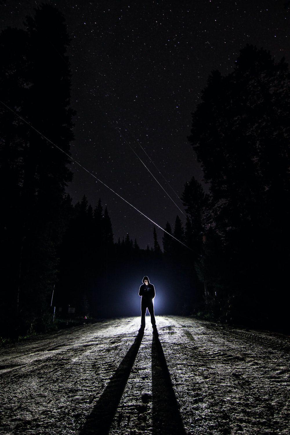 1000x1500 man standing on pathway during nighttime photo