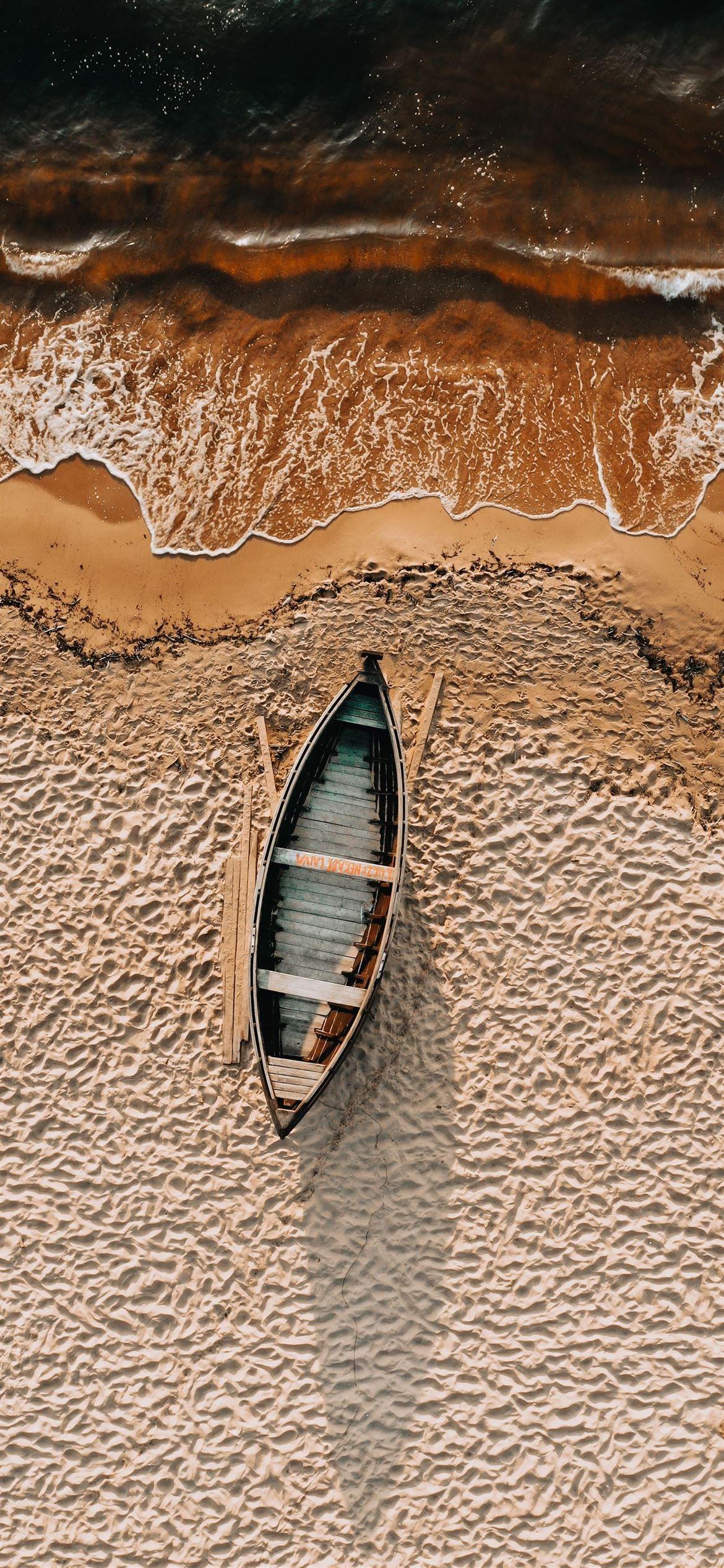 1170x2532 brown and white boat on brown sand iPhone 12 Wallpaper Free Download