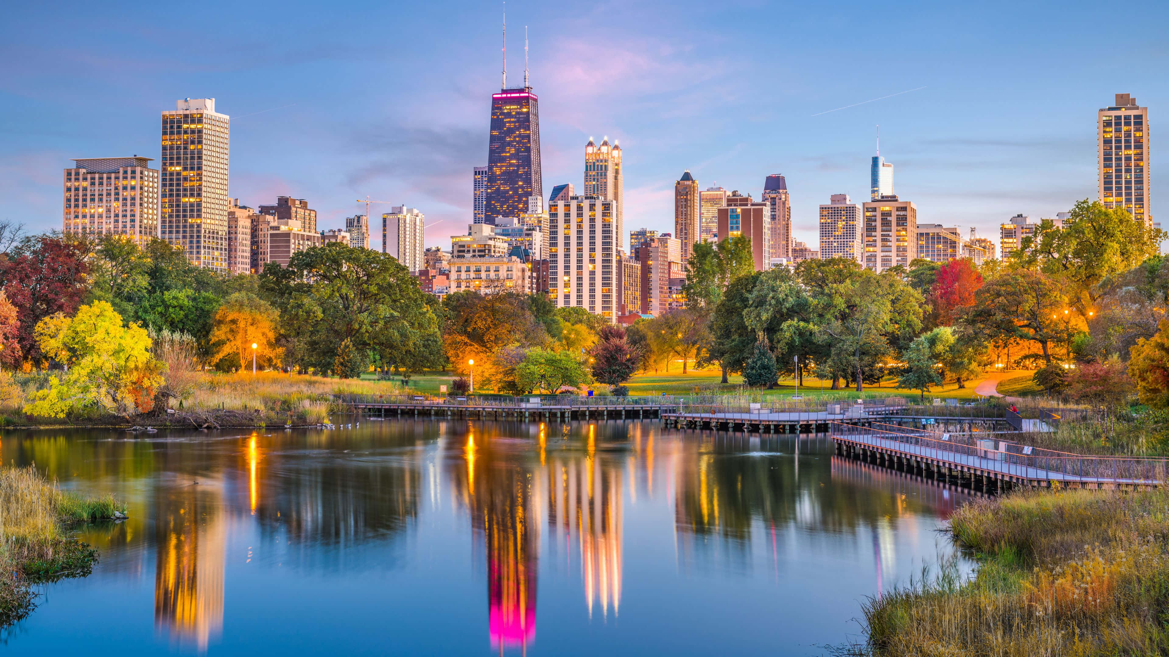 3840x2160 Download The glimmering lights of the Chicago skyline, reflecting in the waters of Lake Michigan. Wallpaper
