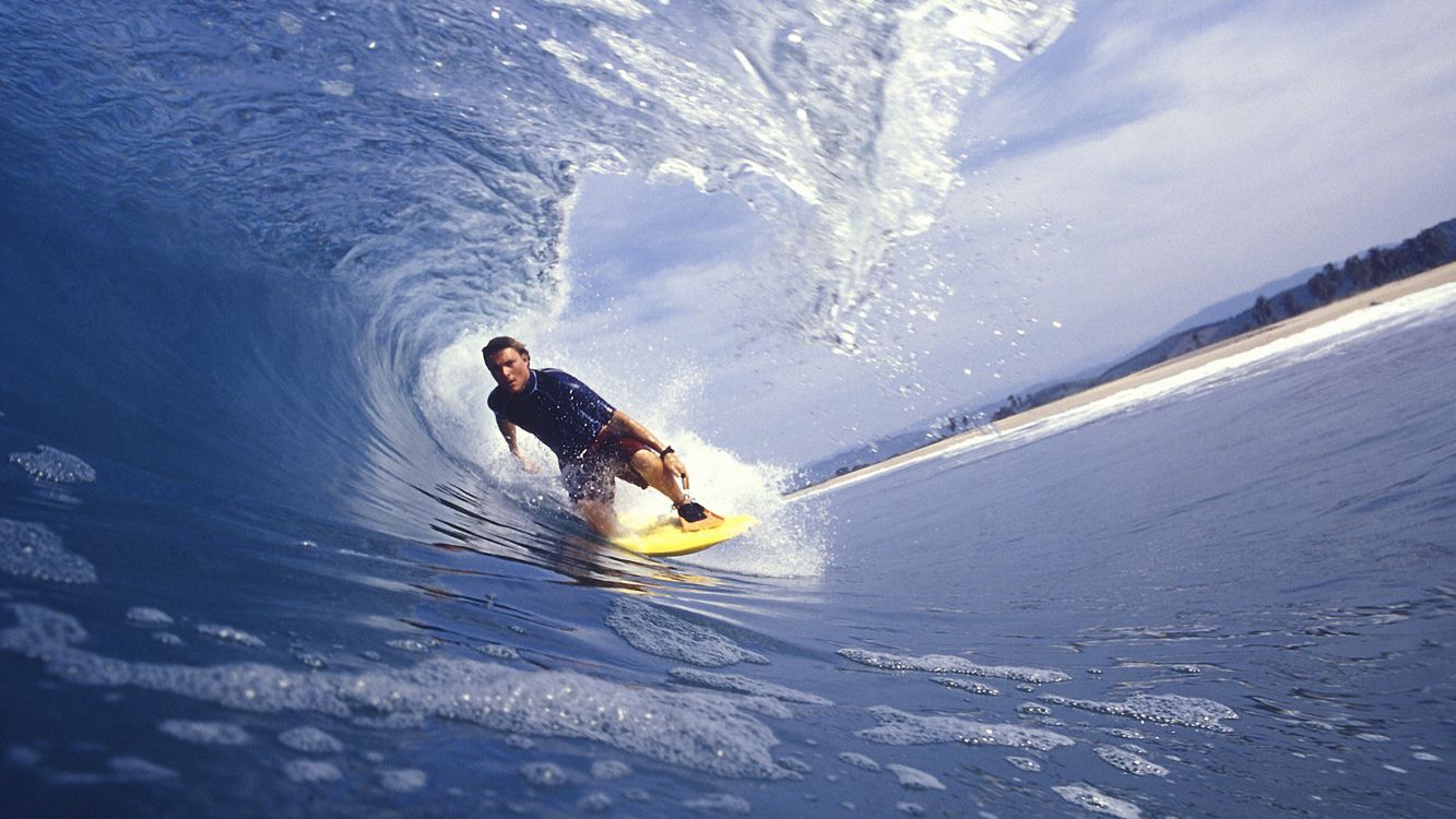 1333x750 Wallpaper Man in Black Wetsuit Riding Yellow Surfboard on Blue Ocean Water During Daytime, Background Free Image