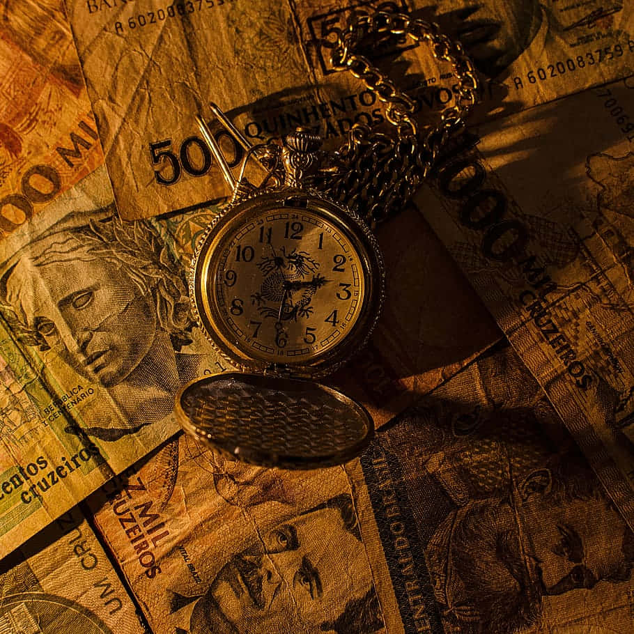 910x910 Download Time_and_ Wealth_ Vintage_ Pocket_ Watch_and_ Currency_ Background Wallpaper