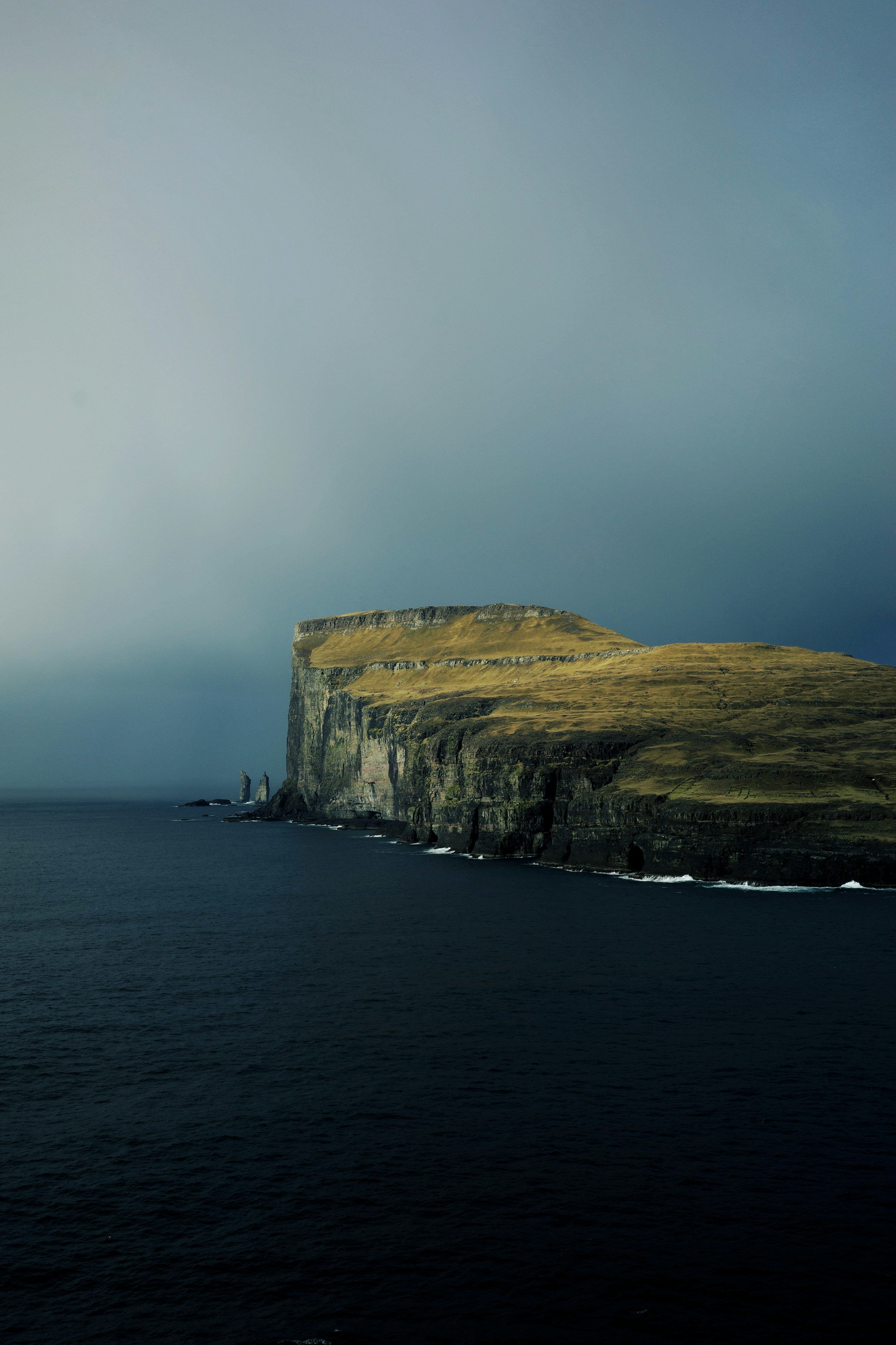 3000x4500 Cliffside with dark water under a stormy sky