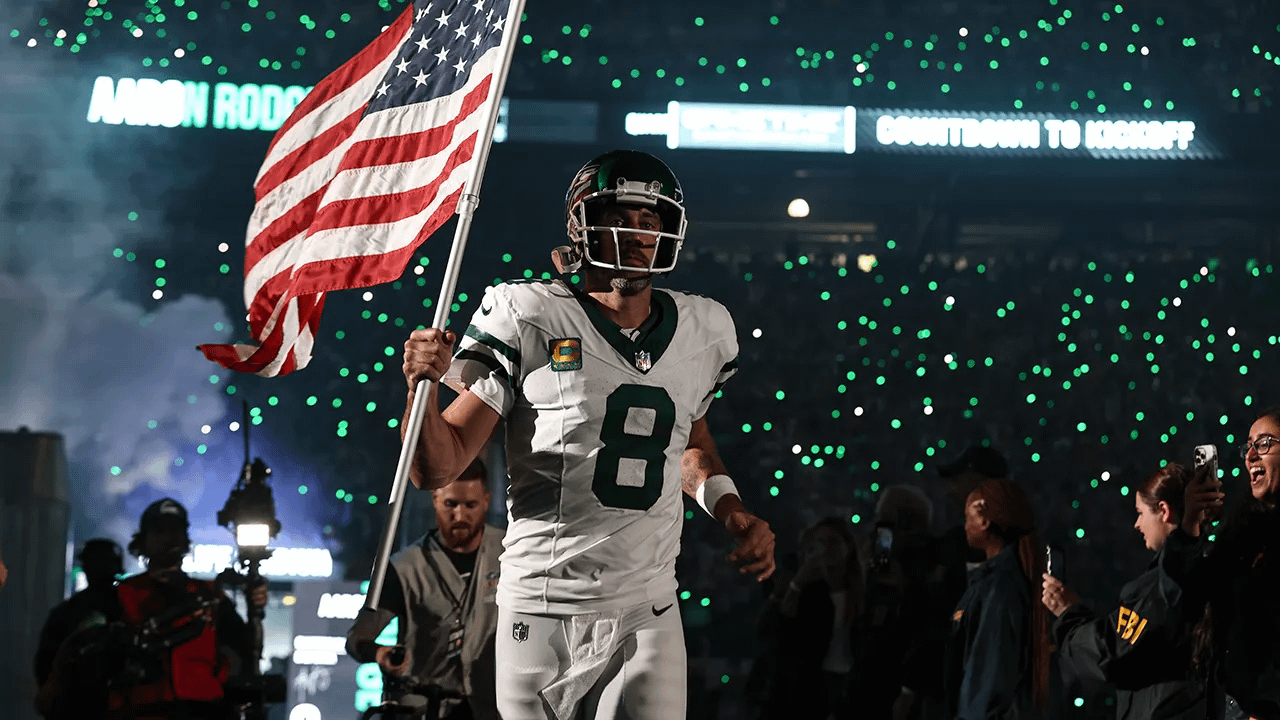 1280x720 Wallpaper of Aaron Rodgers running out with american flag