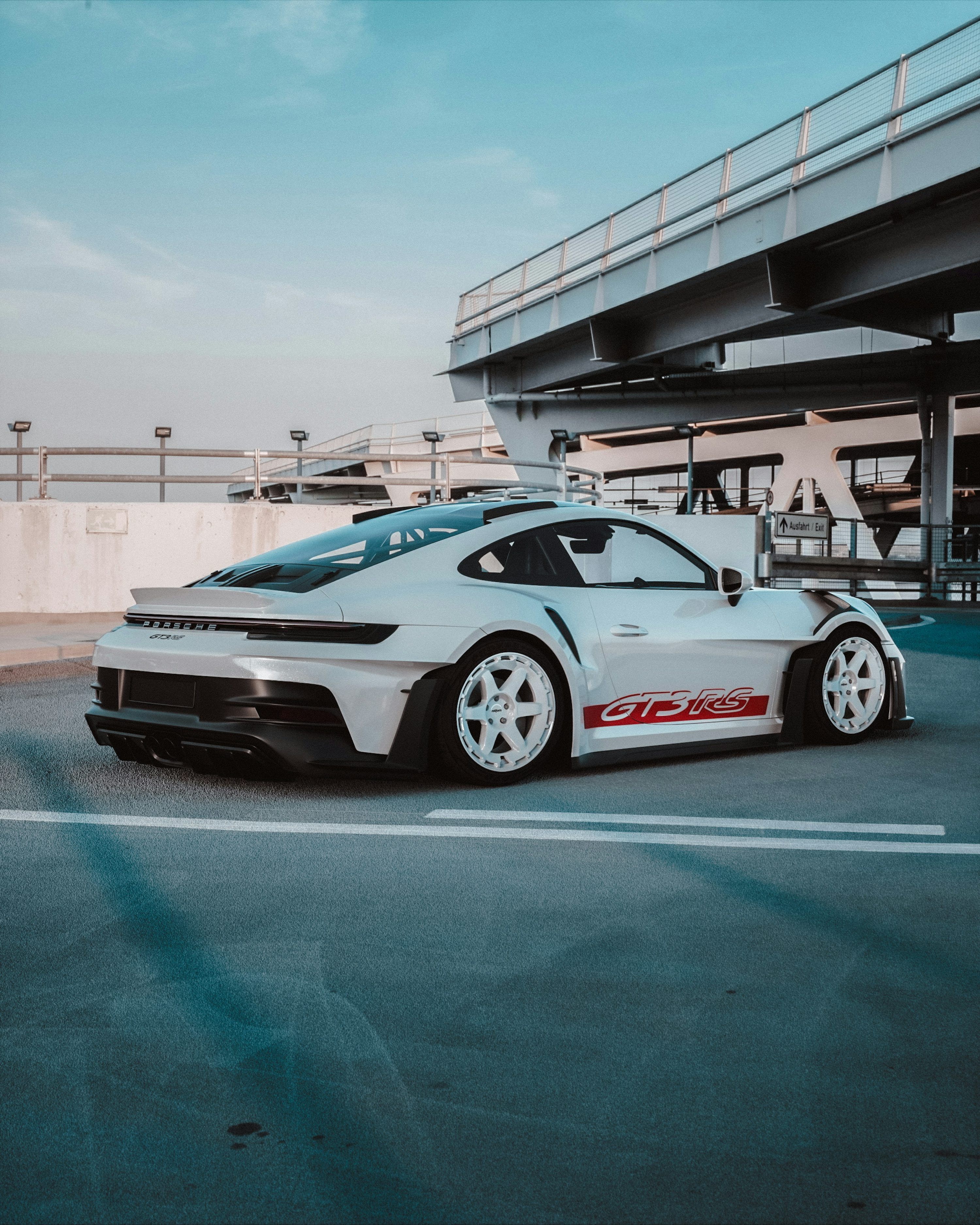 3000x3750 White porsche sports car parked in a parking garage