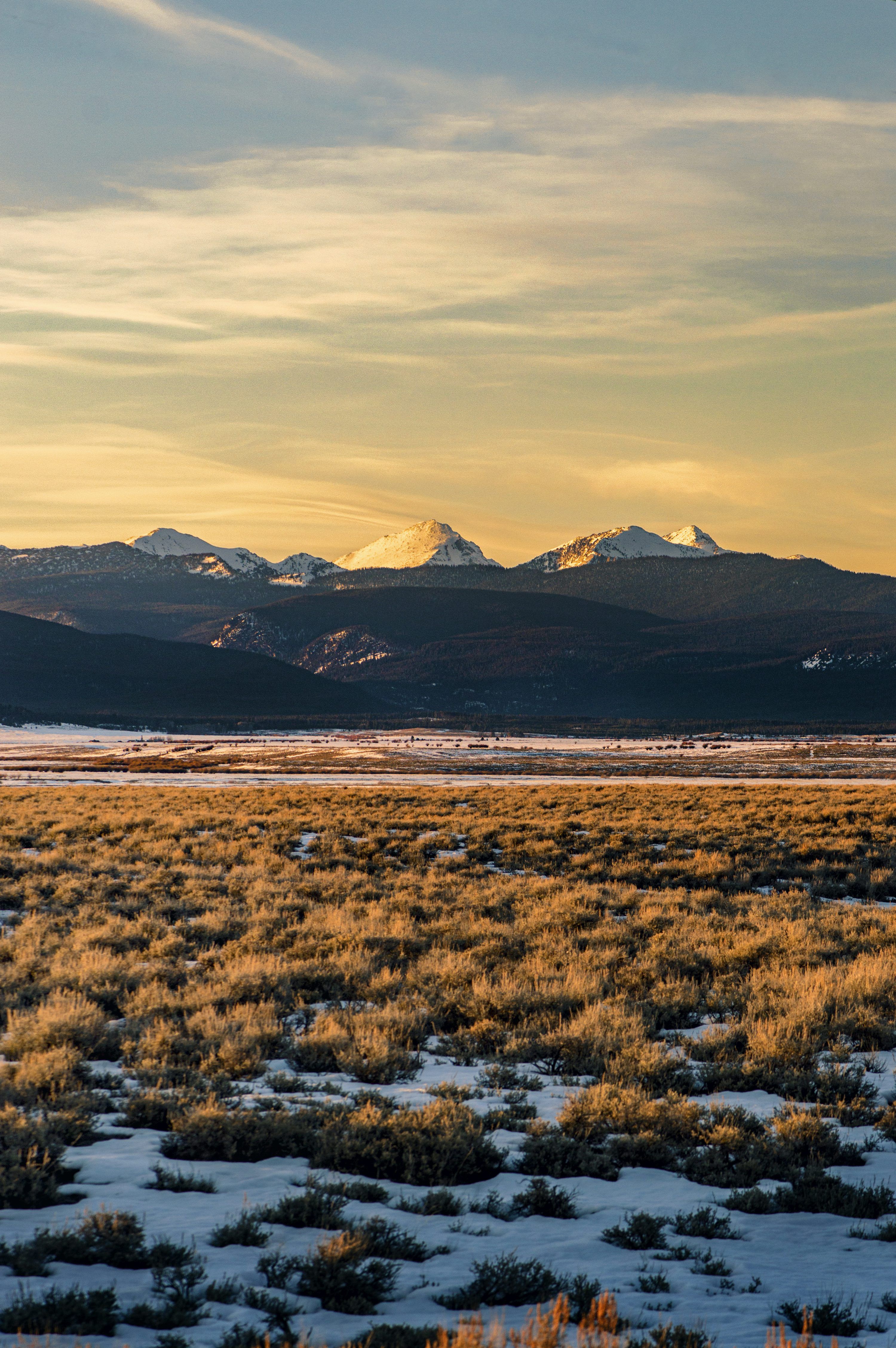 3000x4512 A large open field with mountains in the background