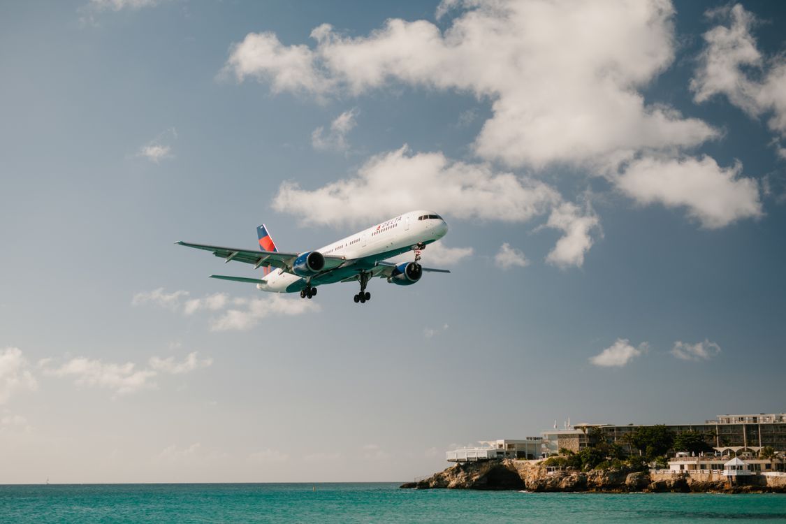 1125x750 An Airplane Over the Sea · Free