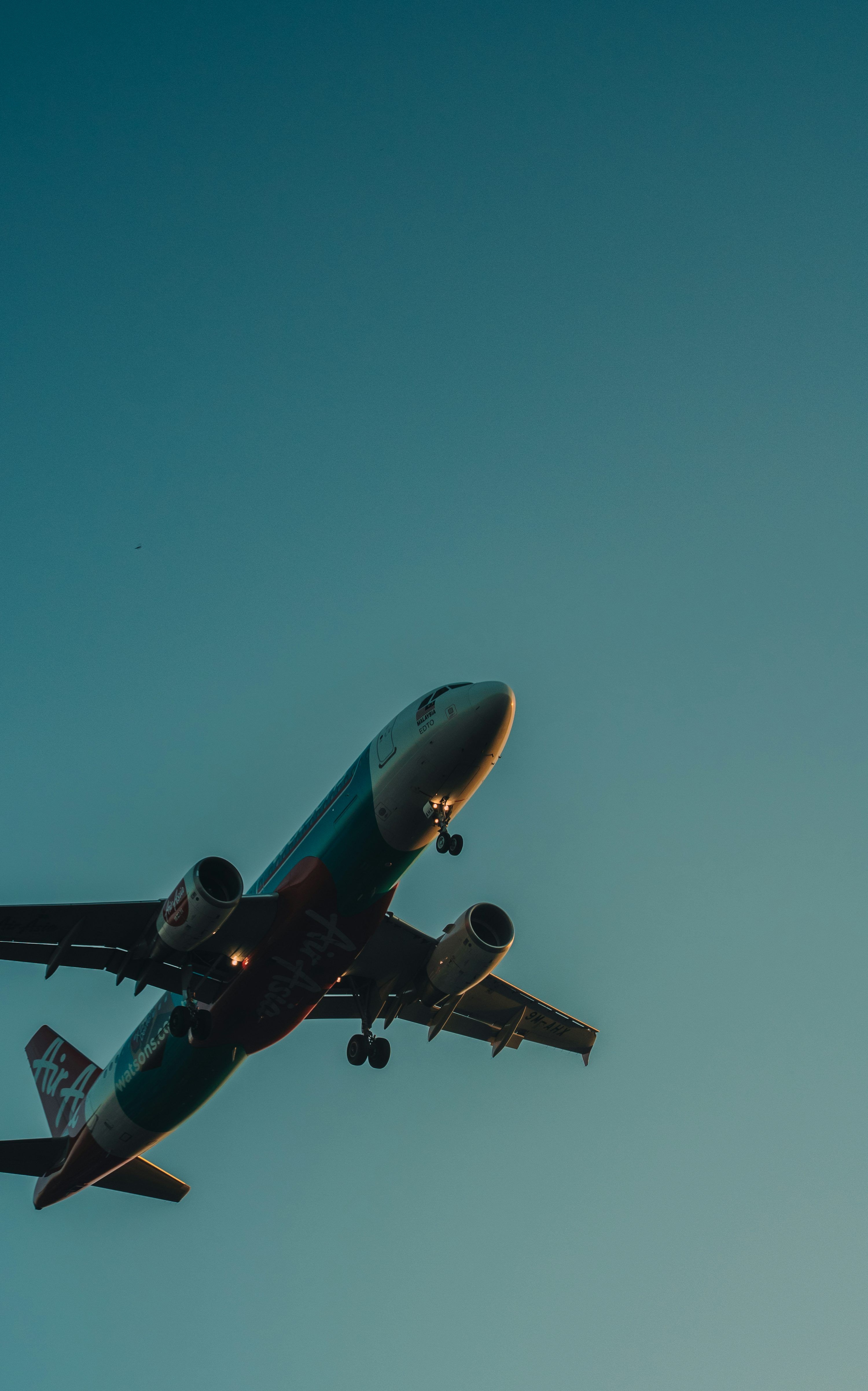 3000x4805 Commercial airplane with landing gear down against a blue sky