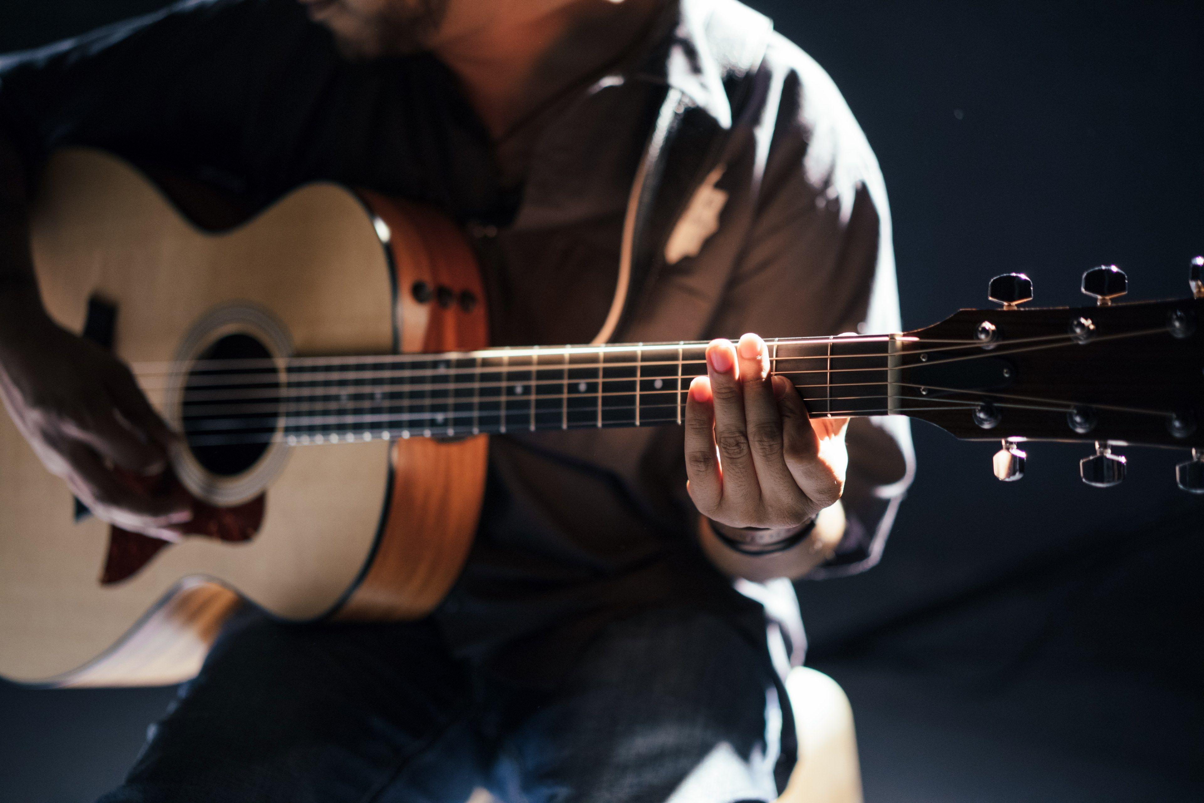 3840x2563 A Seated Person Playing Acoustic Guitar .