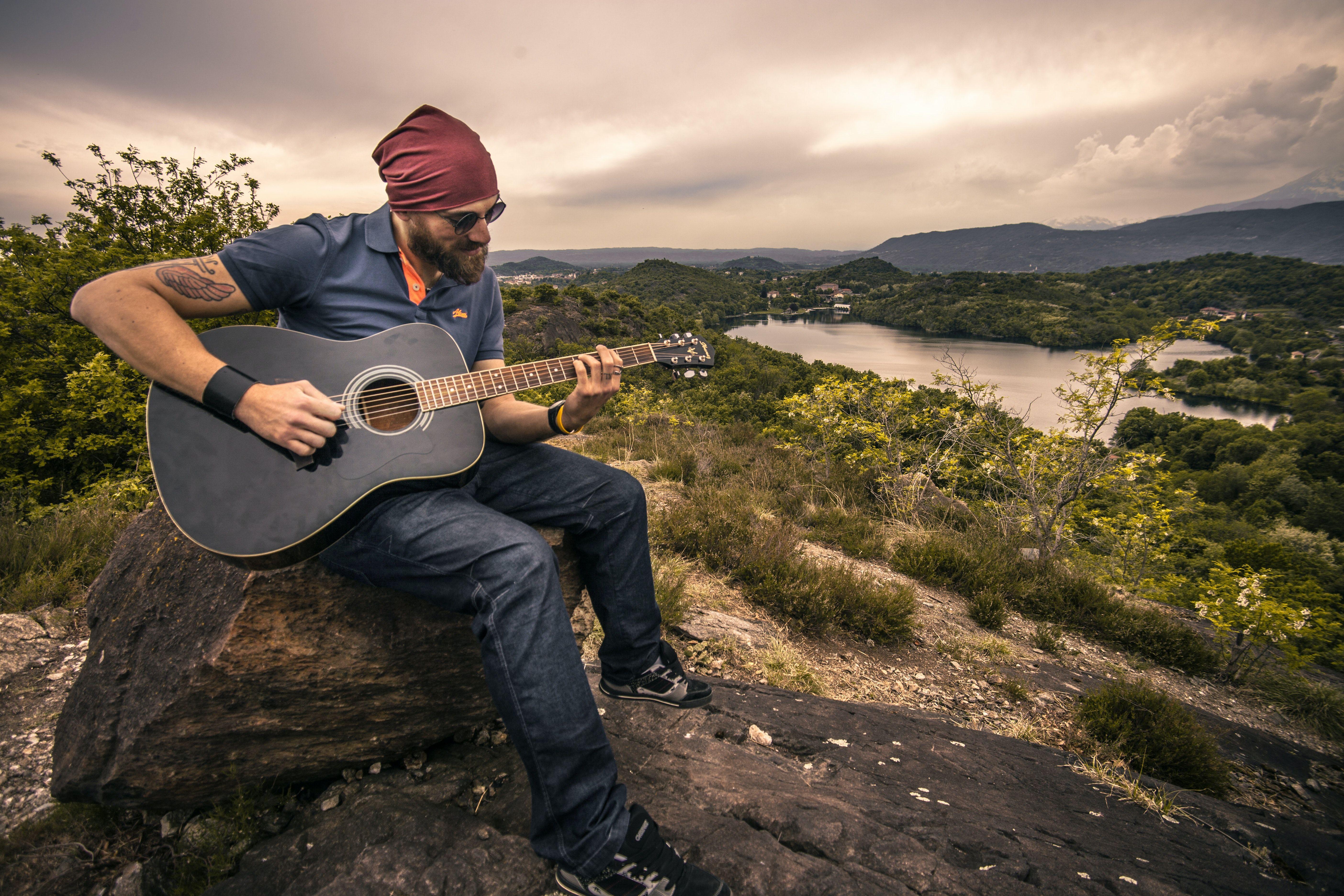 5616x3744 Man Playing Guitar Sitting on Brown .
