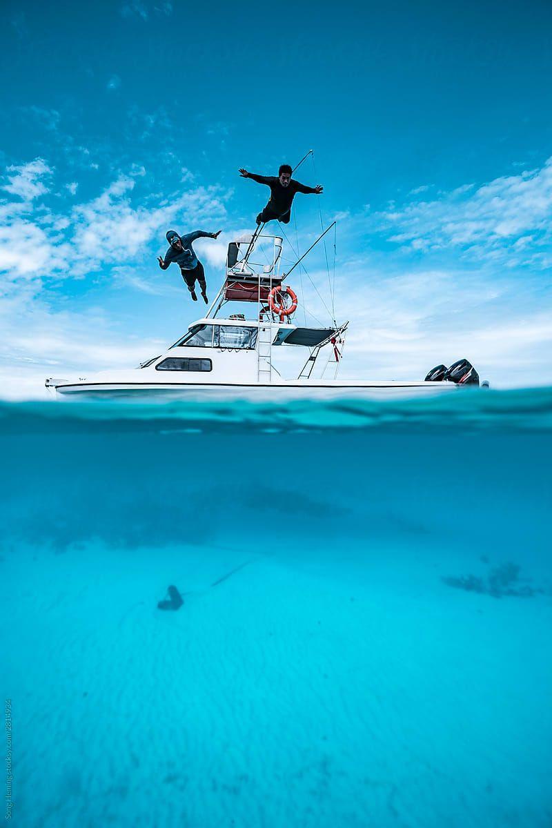 800x1200 Two men jumping off boat into water .