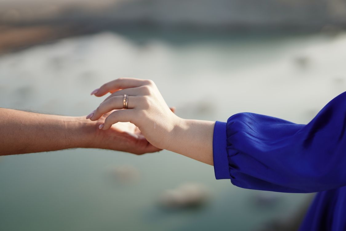 1125x750 A couple holding hands in front of a lake · Free