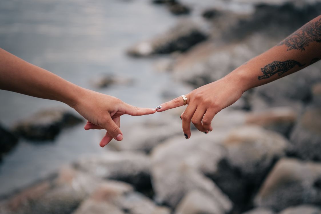 1123x750 Two People Touching Fingers · Free
