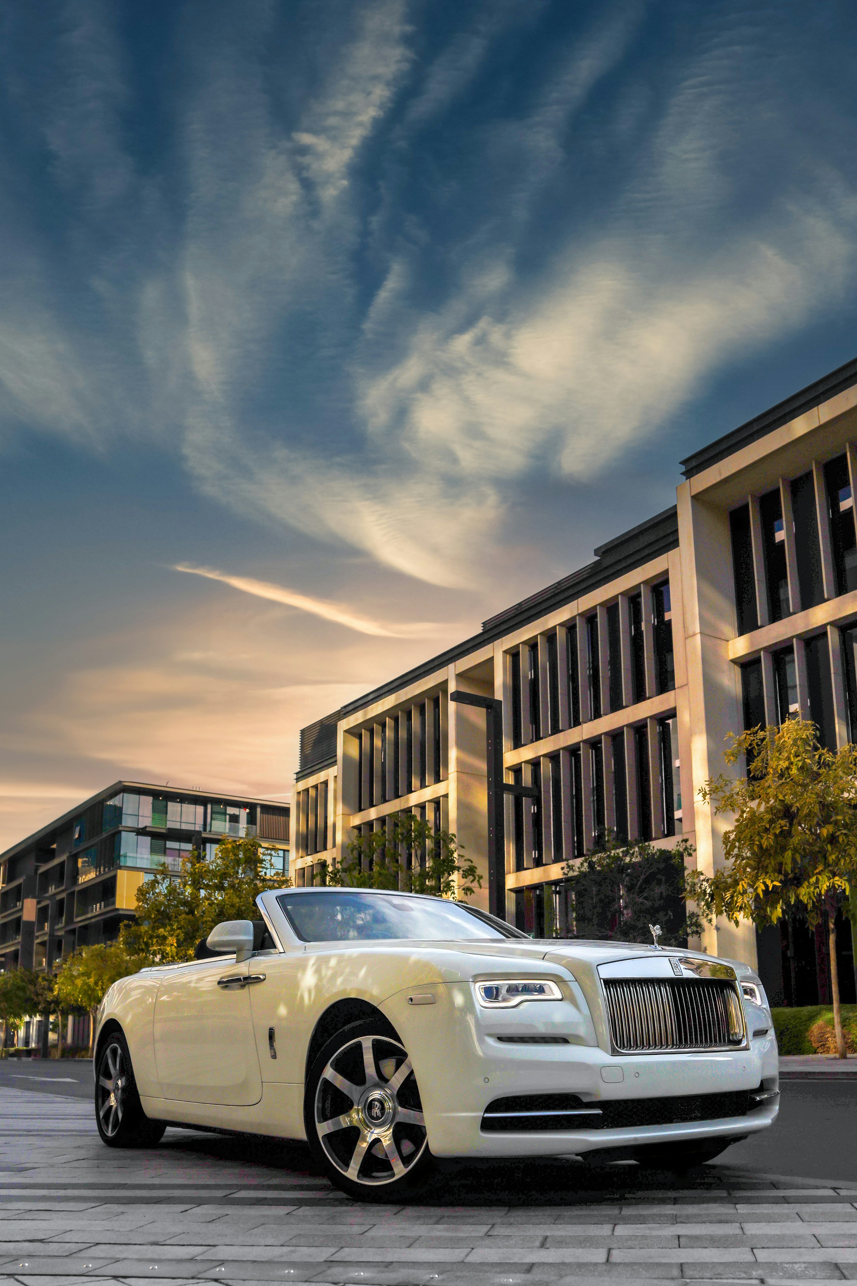 3000x4500 A white rolls royce parked in front of a building