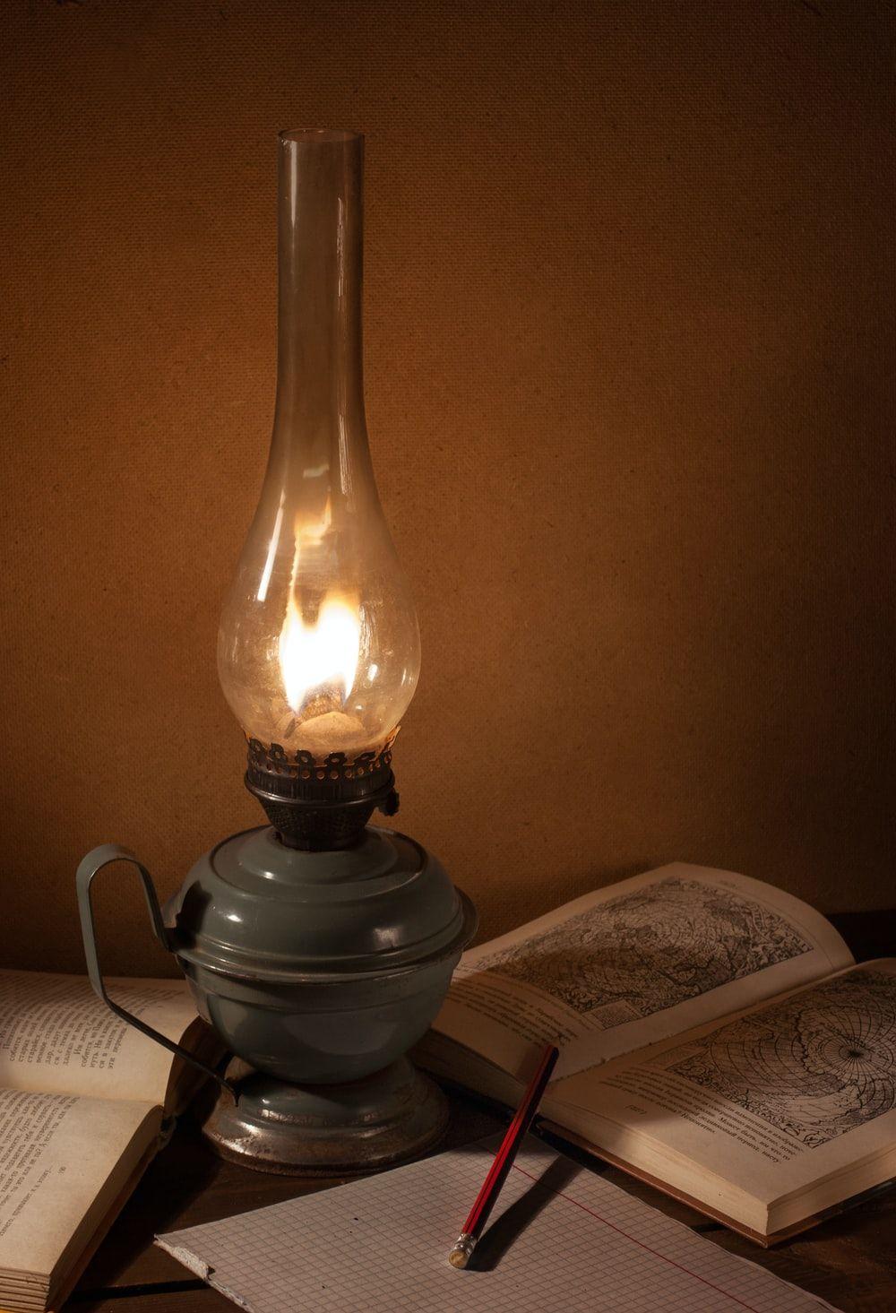 1000x1465 gray oil lamp beside book photo