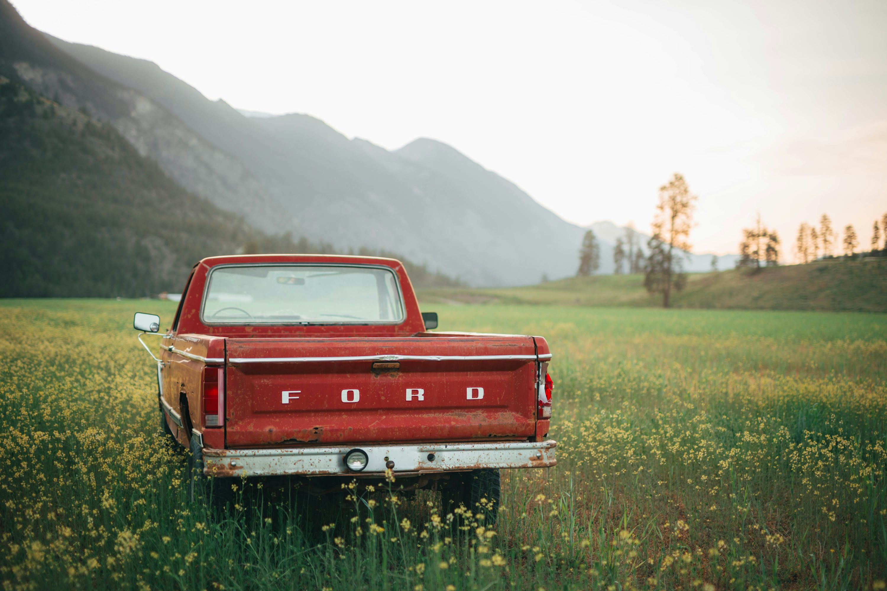 3000x2000 A red ford truck sits in a field