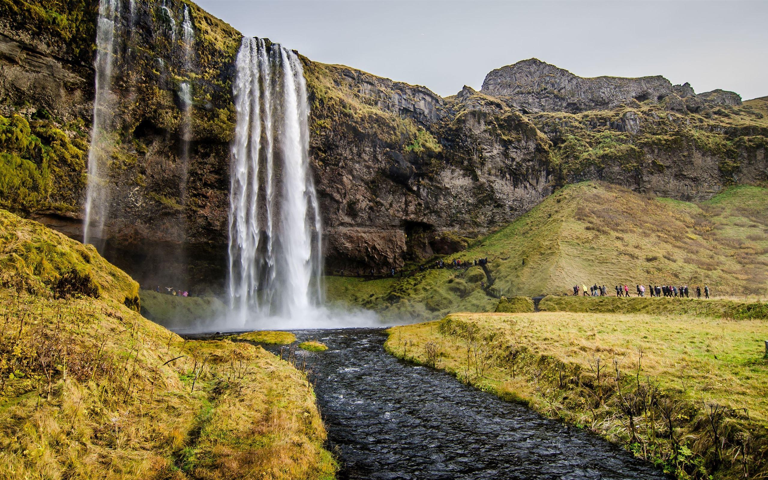 2560x1600 people walking towards waterfalls .