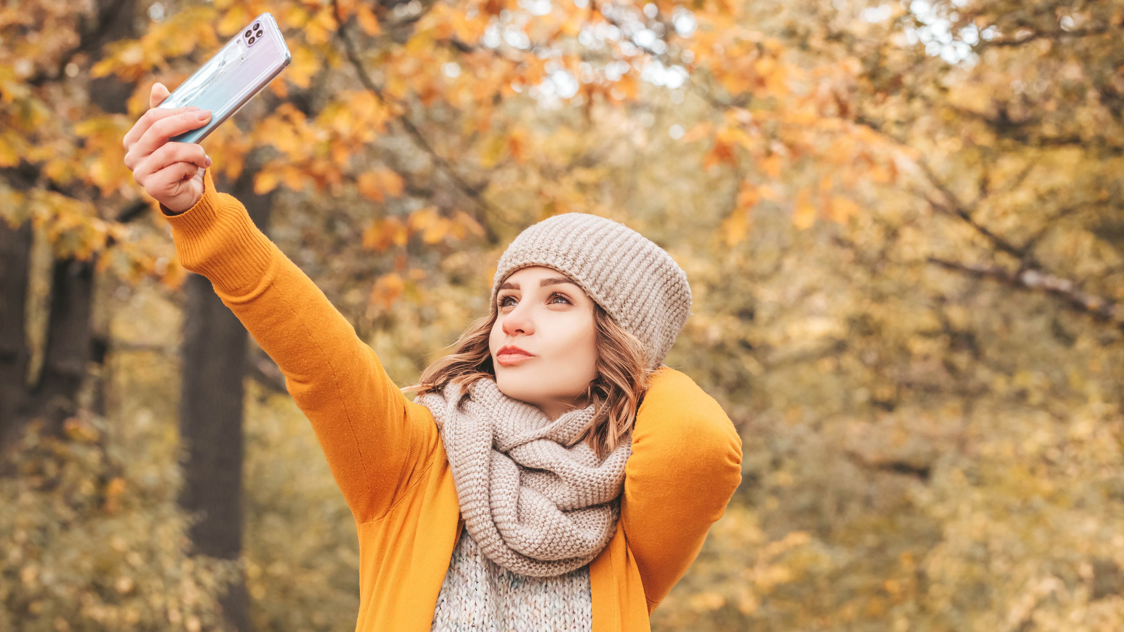 3840x2160 Beautiful Girl Model Is Taking A Selfie Wearing Yellow Dress In Blur Trees Background 4K HD Girls Wallpaper