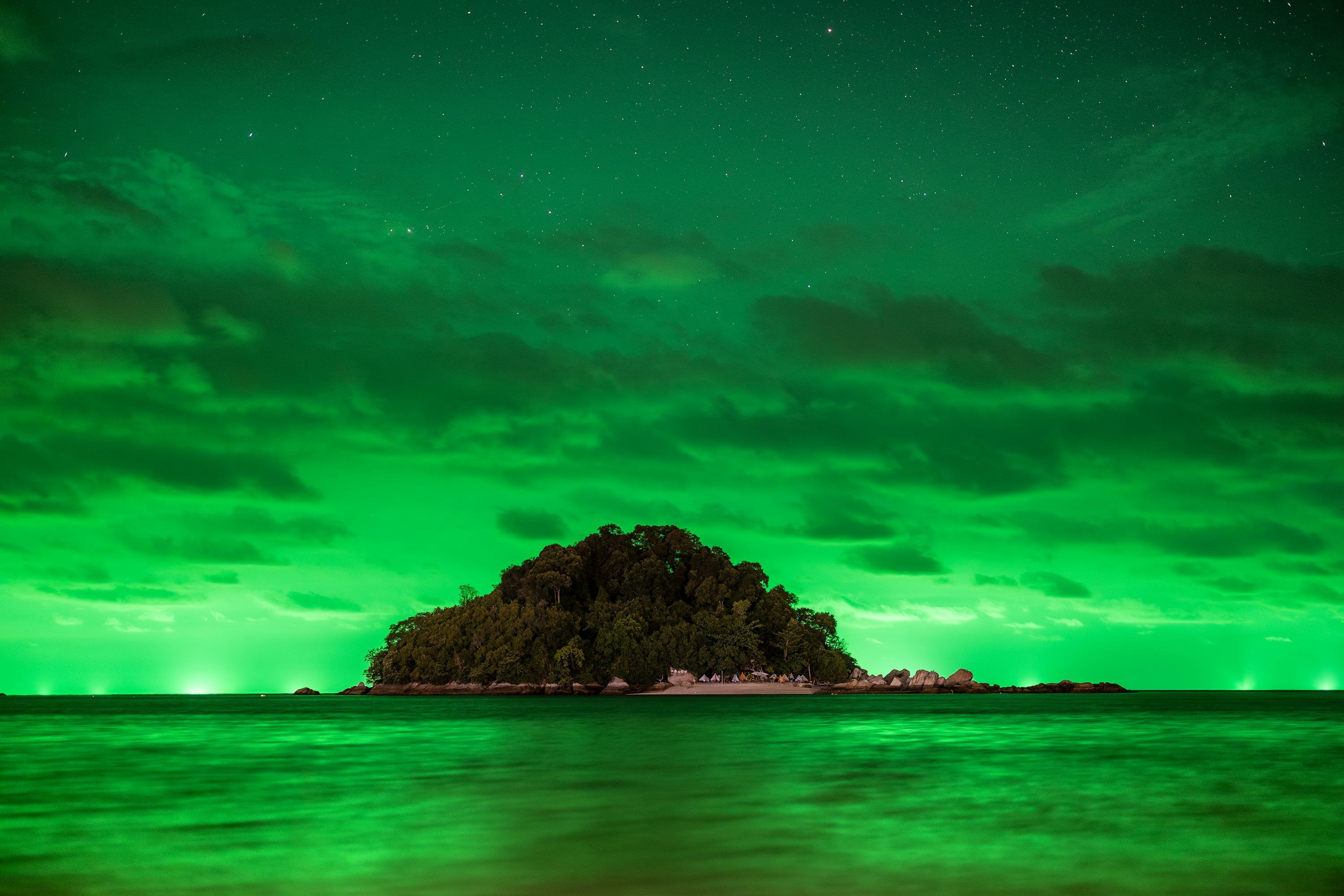 3000x2000 A green island is lit up by the night sky