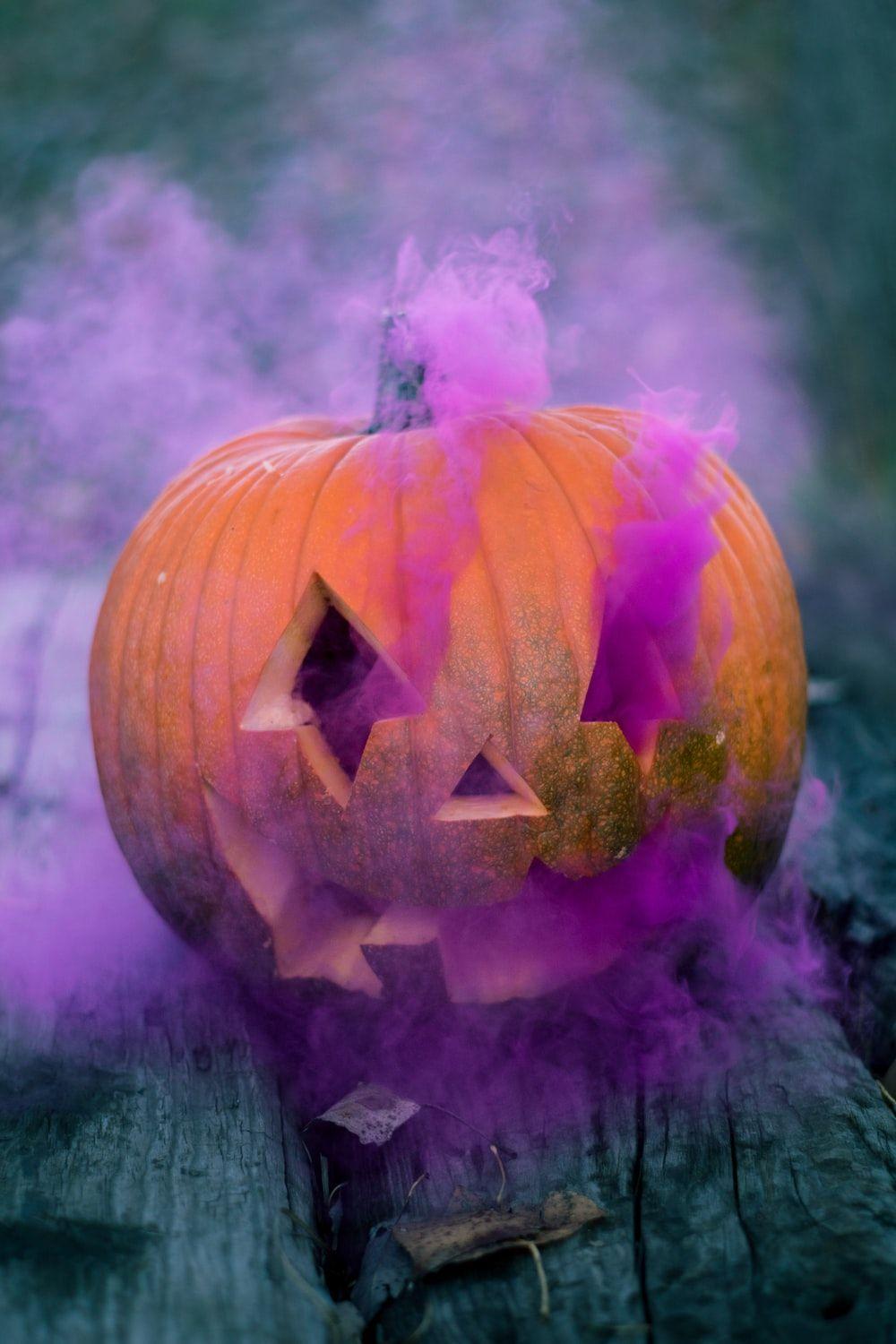 1000x1500 Orange Jack O' Lantern With Pink Smoke On Gray Wooden Surface Photo