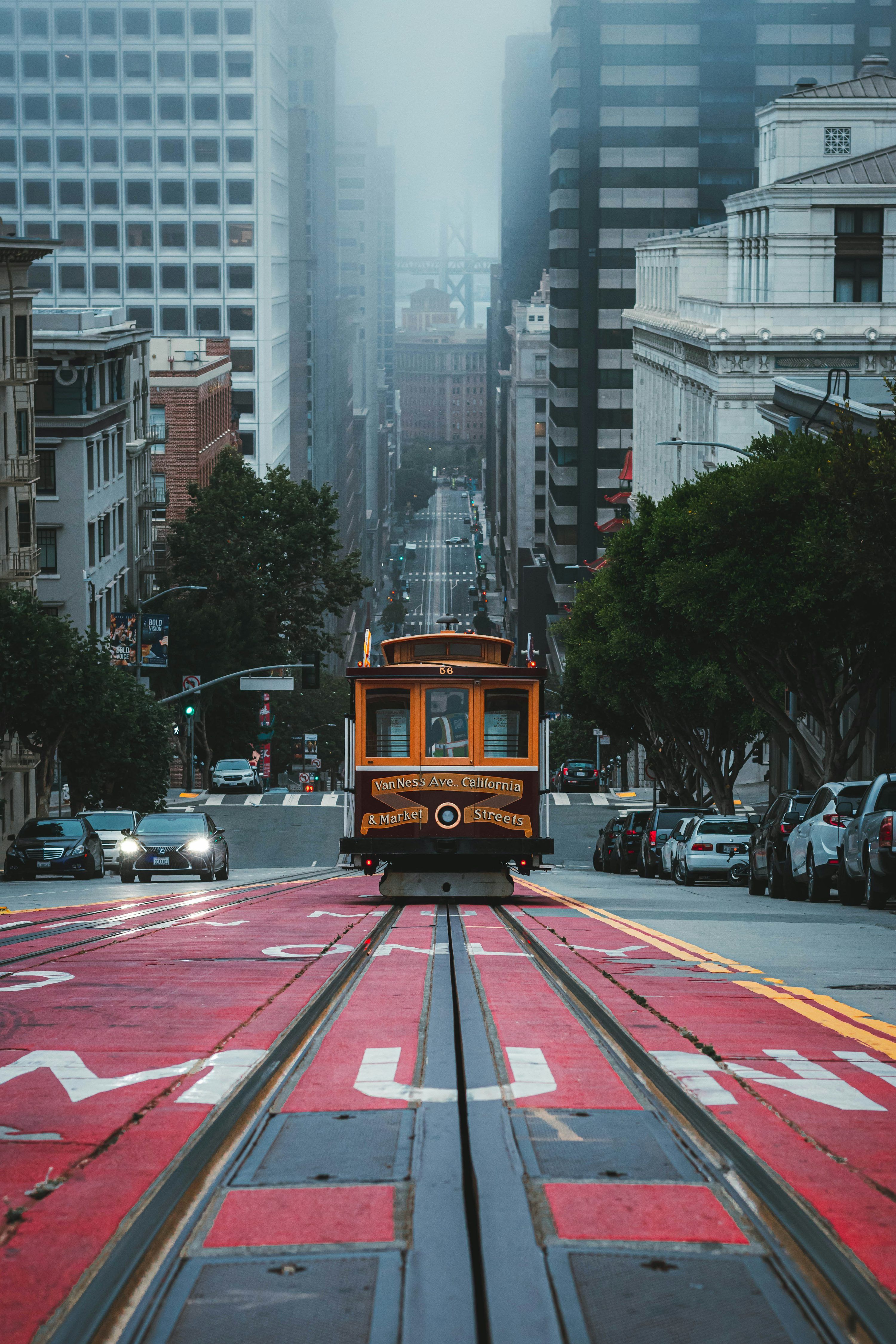3000x4500 A trolley car traveling down a street next to tall buildings