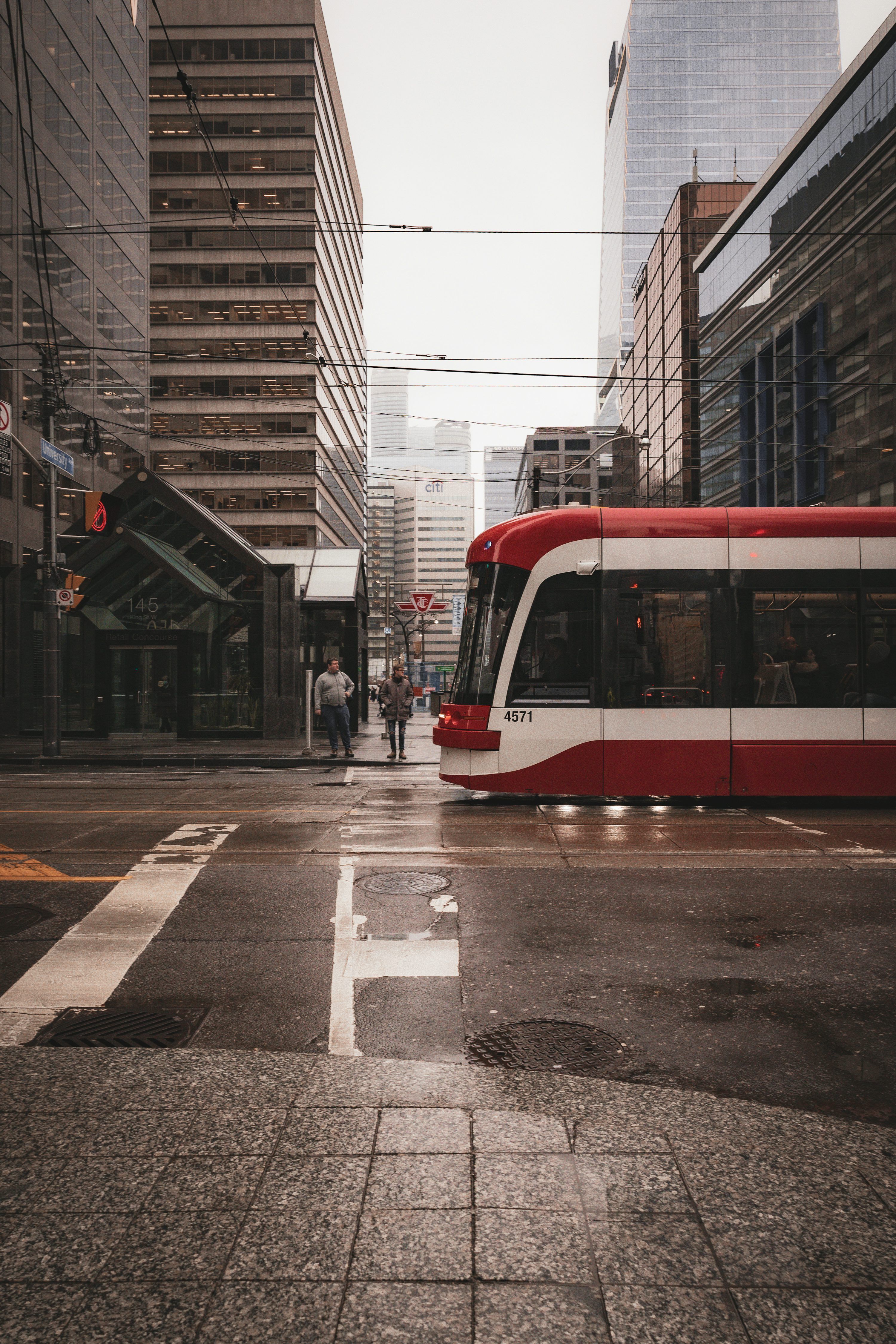 3000x4500 A red and white train on a city street photo