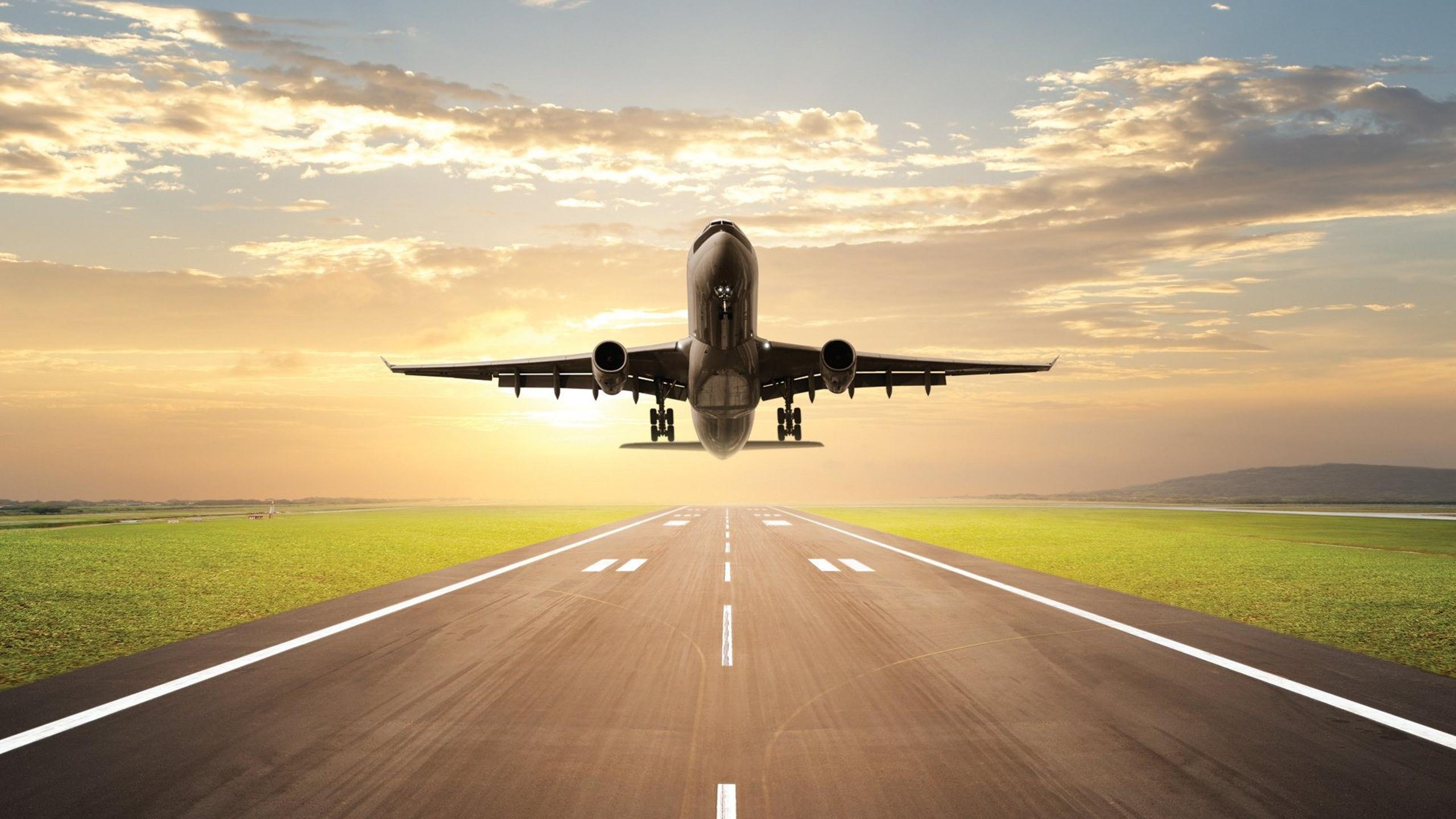 2560x1440 Plane lands on the runway on sunrise