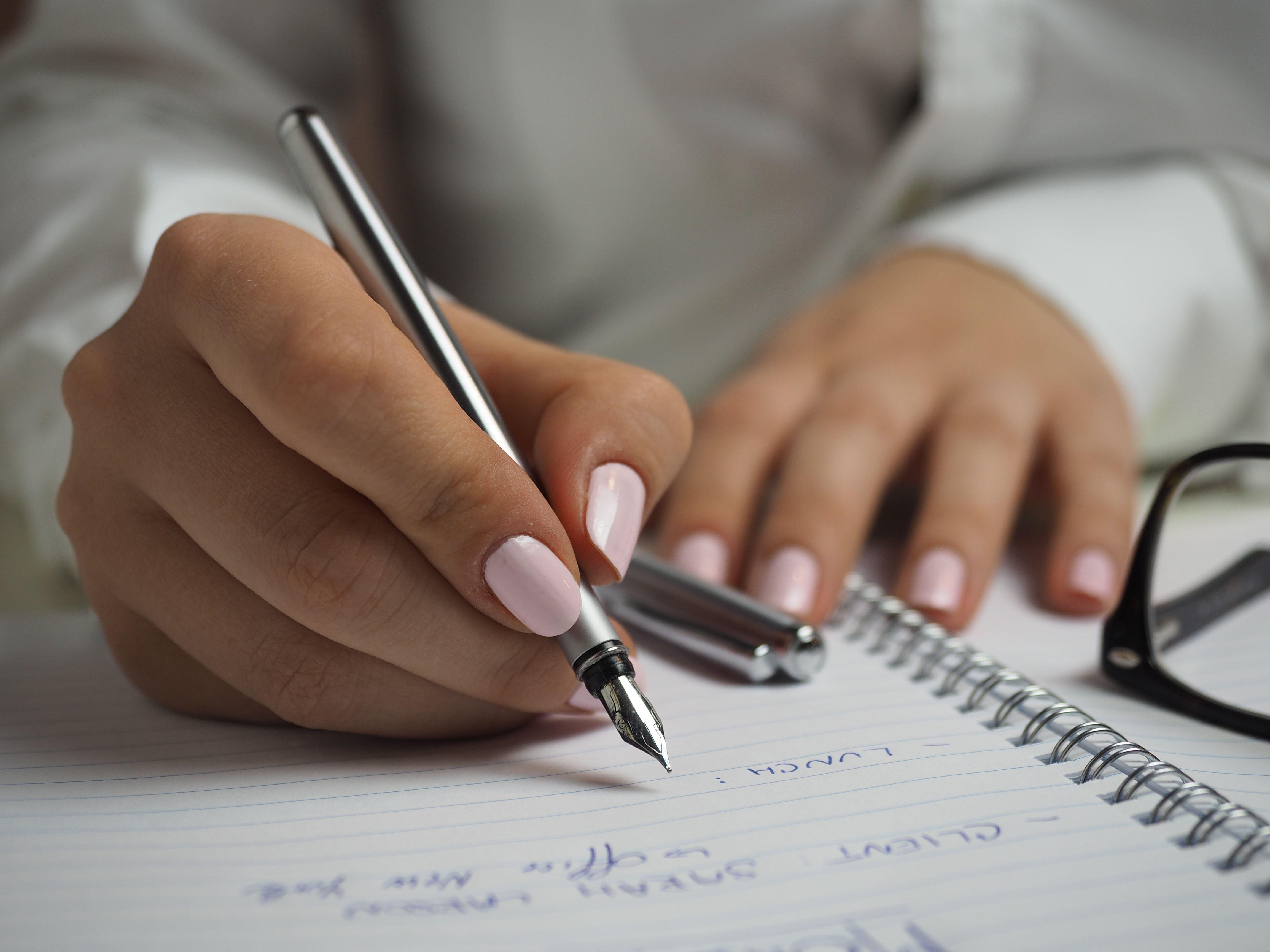 4608x3456 Woman in White Long Sleeved Shirt Holding a Pen Writing on a Paper · Free