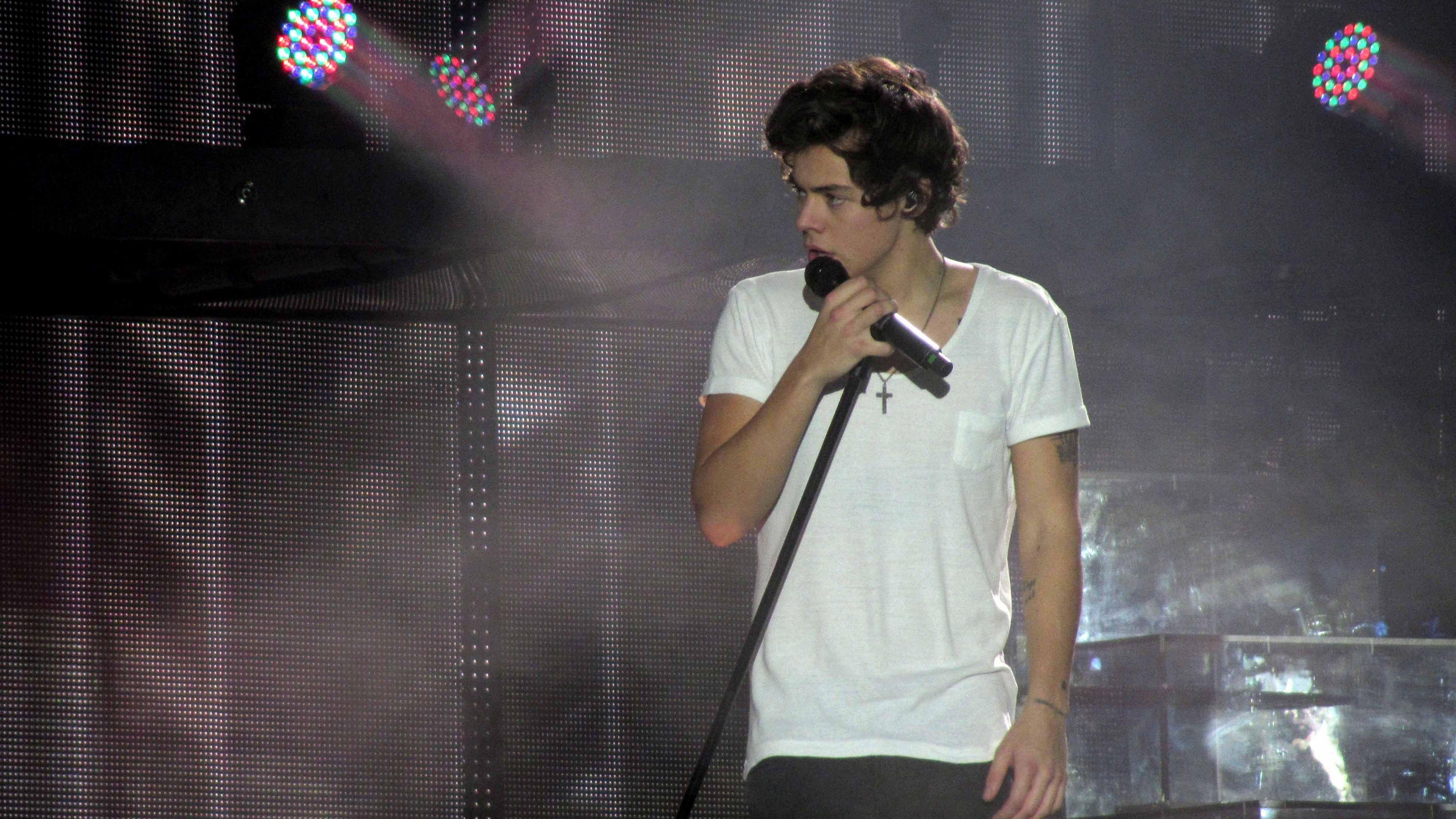 3840x2160 Harry Styles Is Singing With Mike Wearing White T Shirt In Stage Background 4K HD Harry Styles Wallpaper